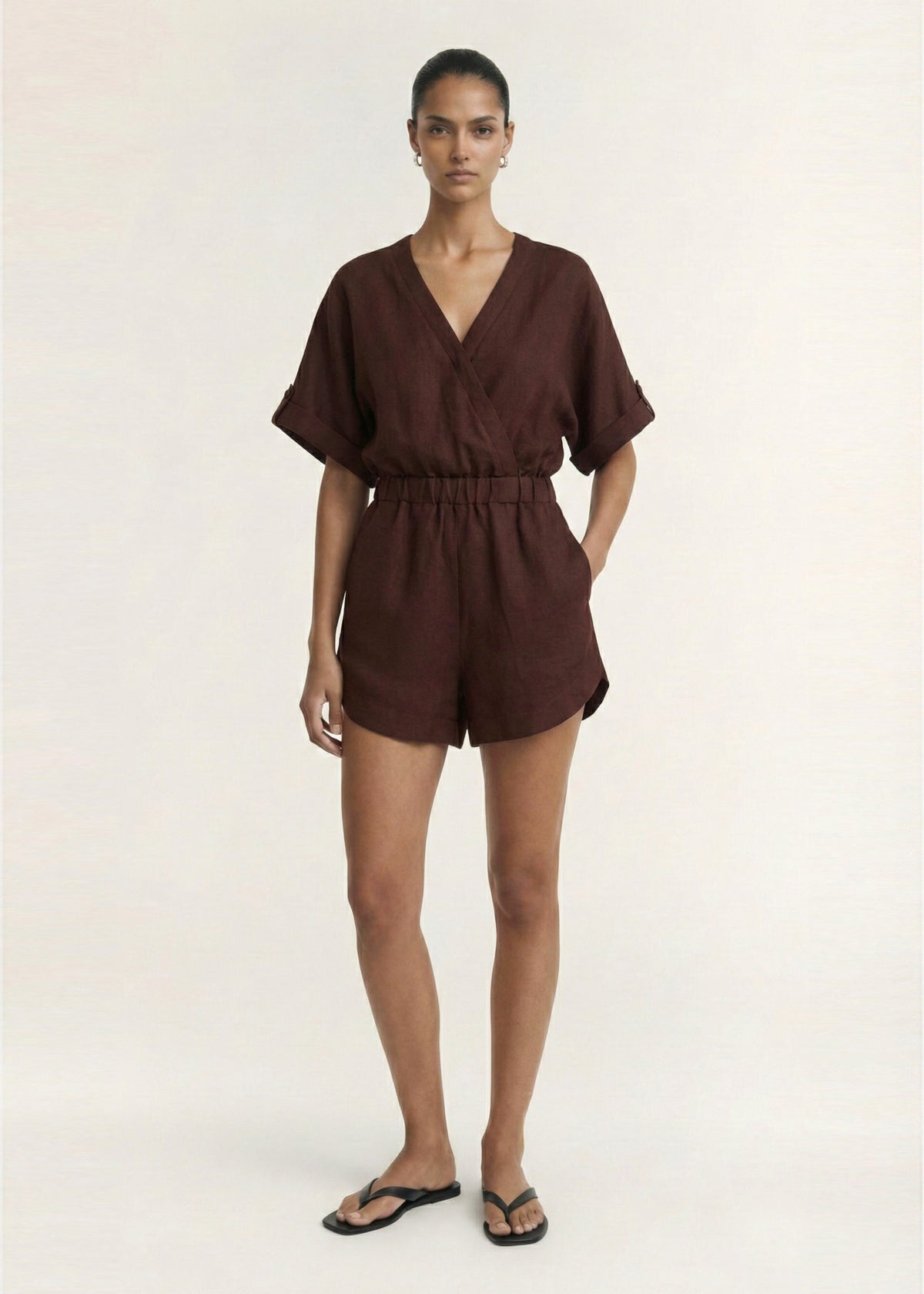Model wearing Chocolate Linen Blend Wrap Playsuit with a dolman sleeves with tab detail and an elasticated waist.