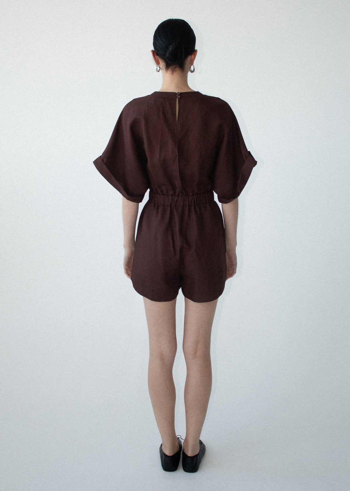 Back view of the Chocolate Linen Blend Wrap Playsuit with a lightweight linen fabrication and a wrap-style V-neckline.
