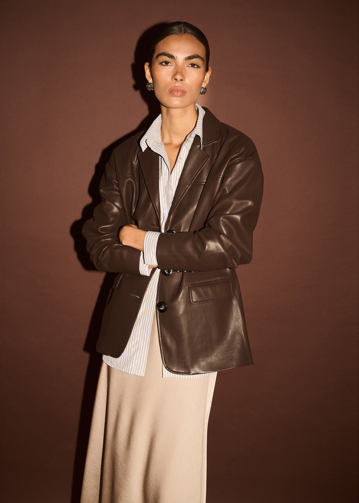 Close-up of the Chocolate Relaxed Vegan Leather Blazer, showing a notched lapel collar and a single-breasted button closure.