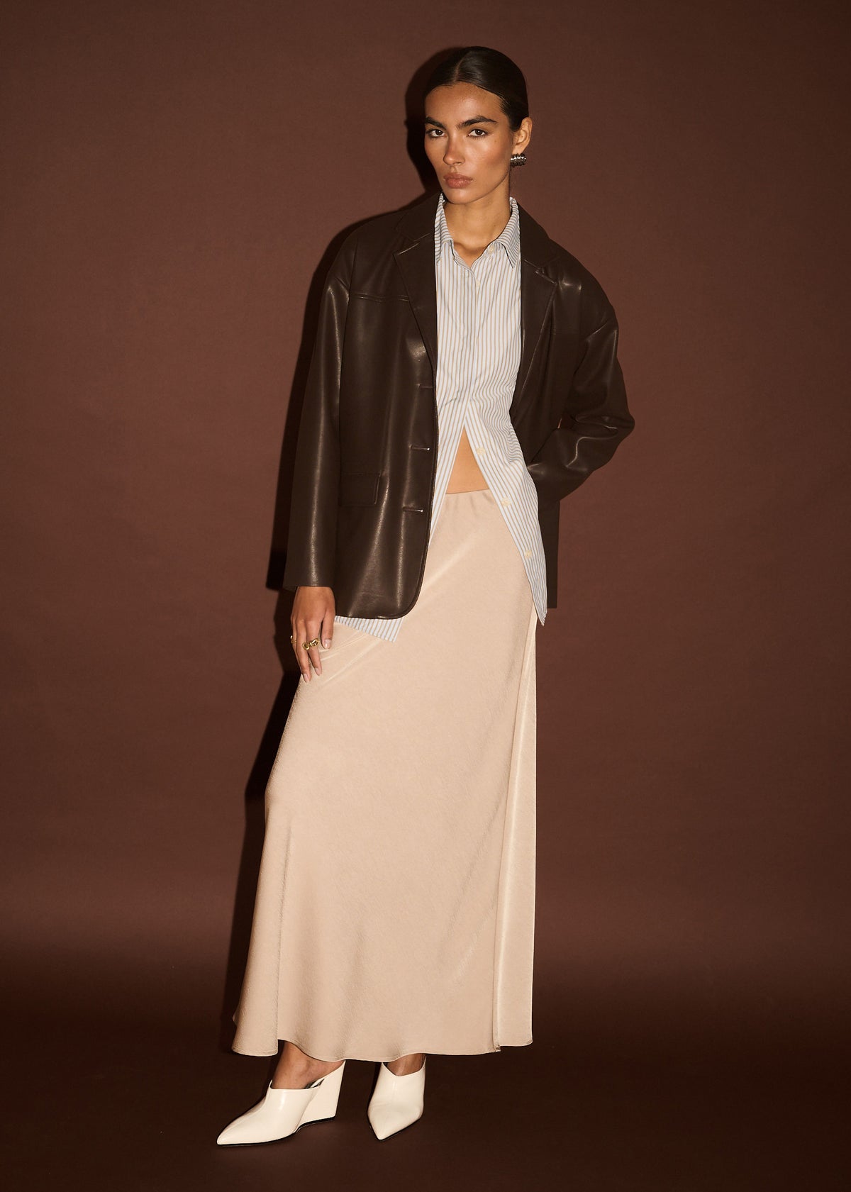 Model wearing Chocolate Relaxed Vegan Leather Blazer with a notched lapel collar and a single-breasted button closure.