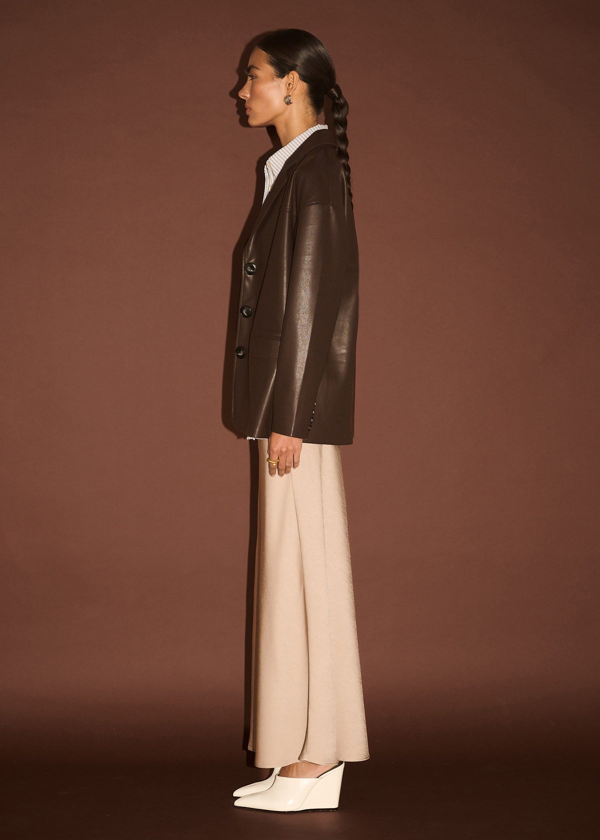 Side view of the Chocolate Relaxed Vegan Leather Blazer, showing structured shoulders and front flap pockets.