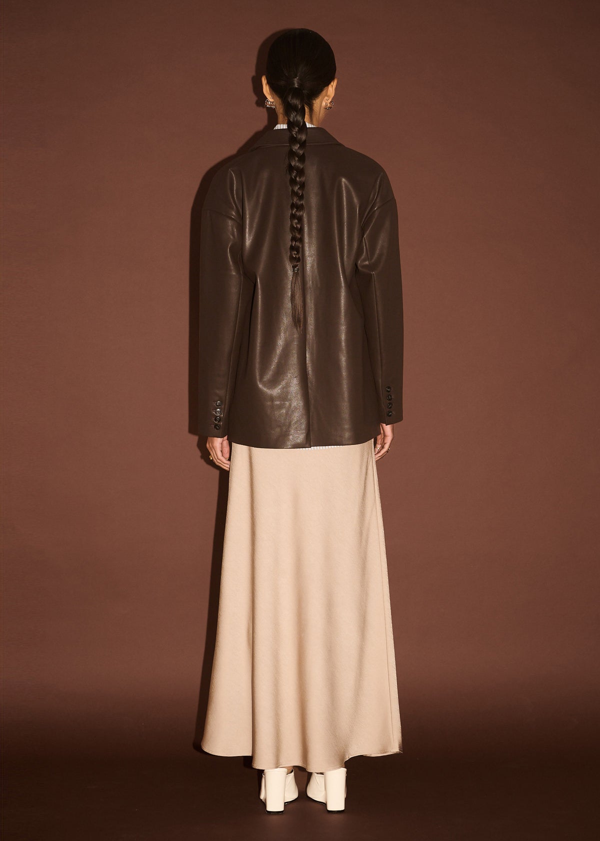 Back view of the Chocolate Relaxed Vegan Leather Blazer with a single-breasted button closure and a relaxed blazer silhouette.