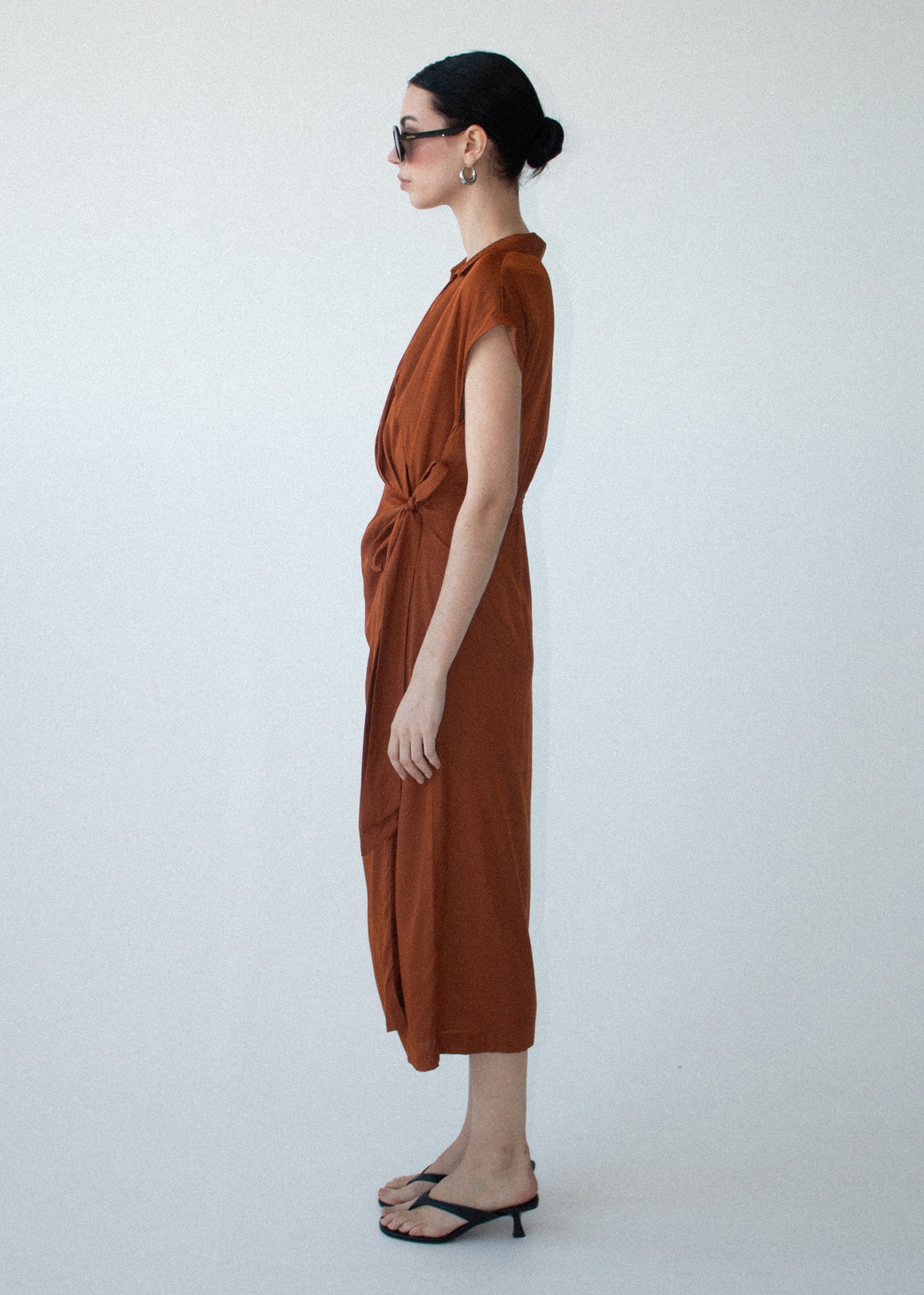 Side view of the Copper Draped Wrap Midi Dress, showing a fluid woven fabrication and an open collar neckline.