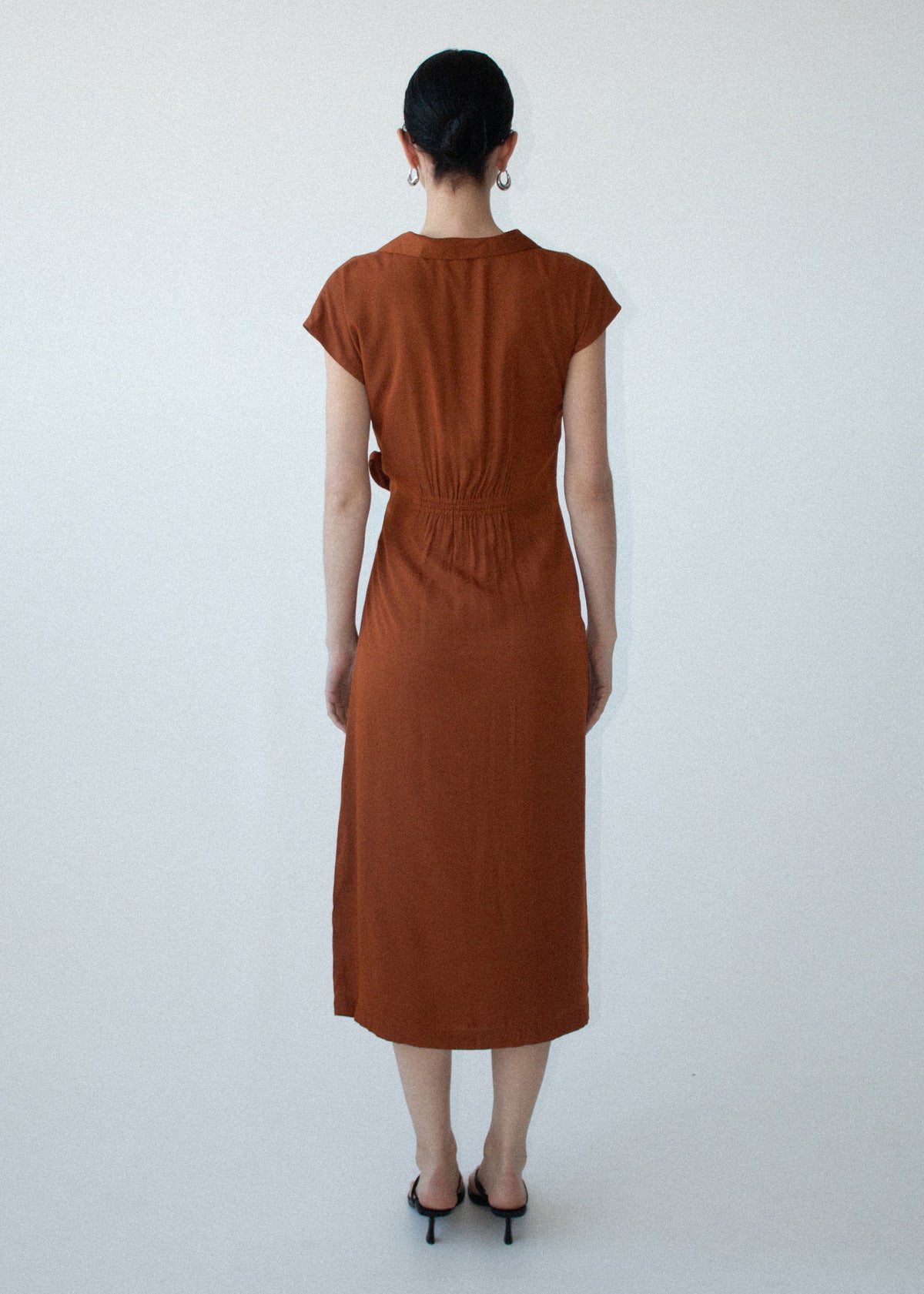 Back view of the Copper Draped Wrap Midi Dress with an open collar neckline and a wrap front with self-tie waist.