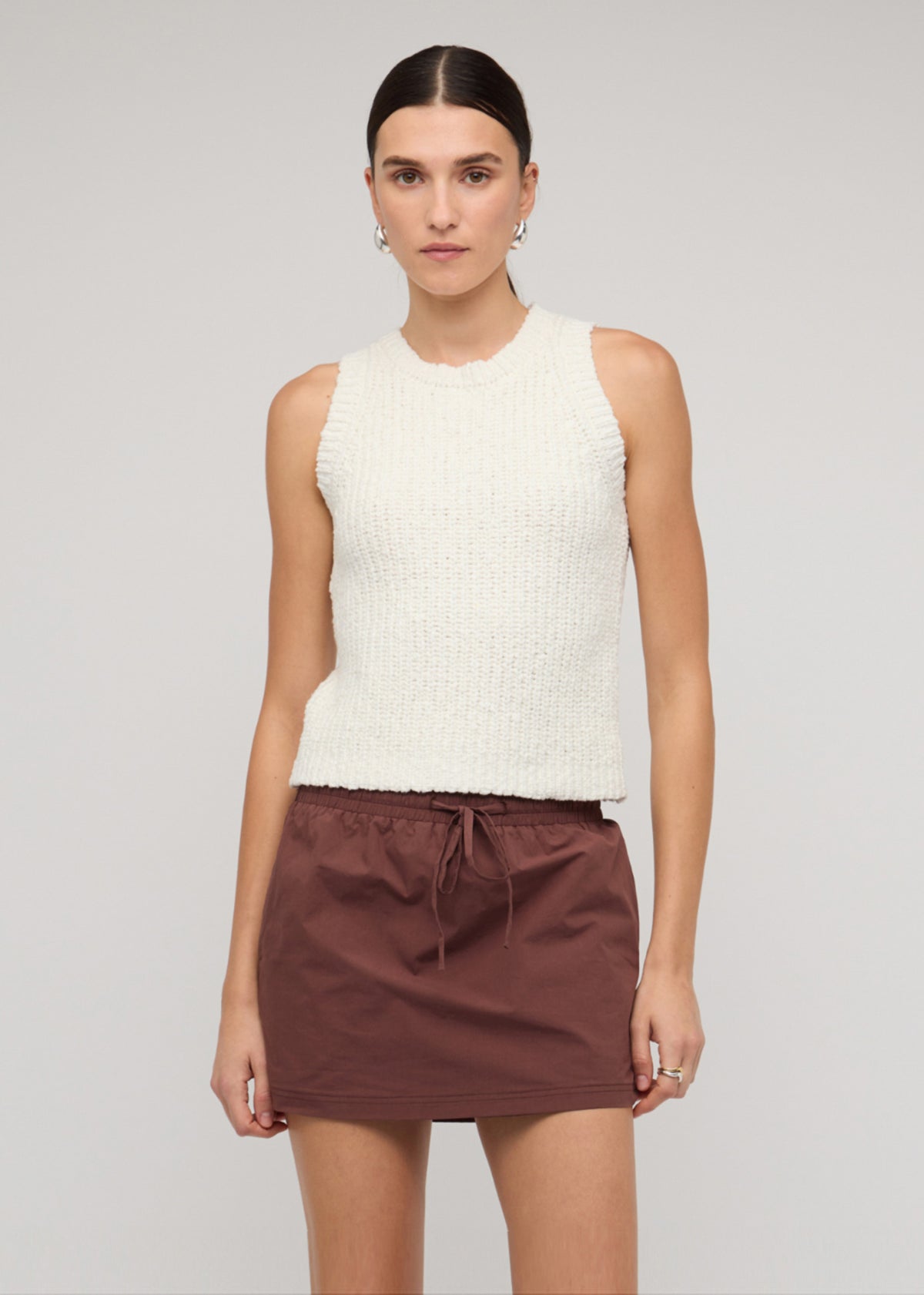 Model wearing Cotton-Blend Knit Tank Top In White with a sleeveless cut and a crew neckline.