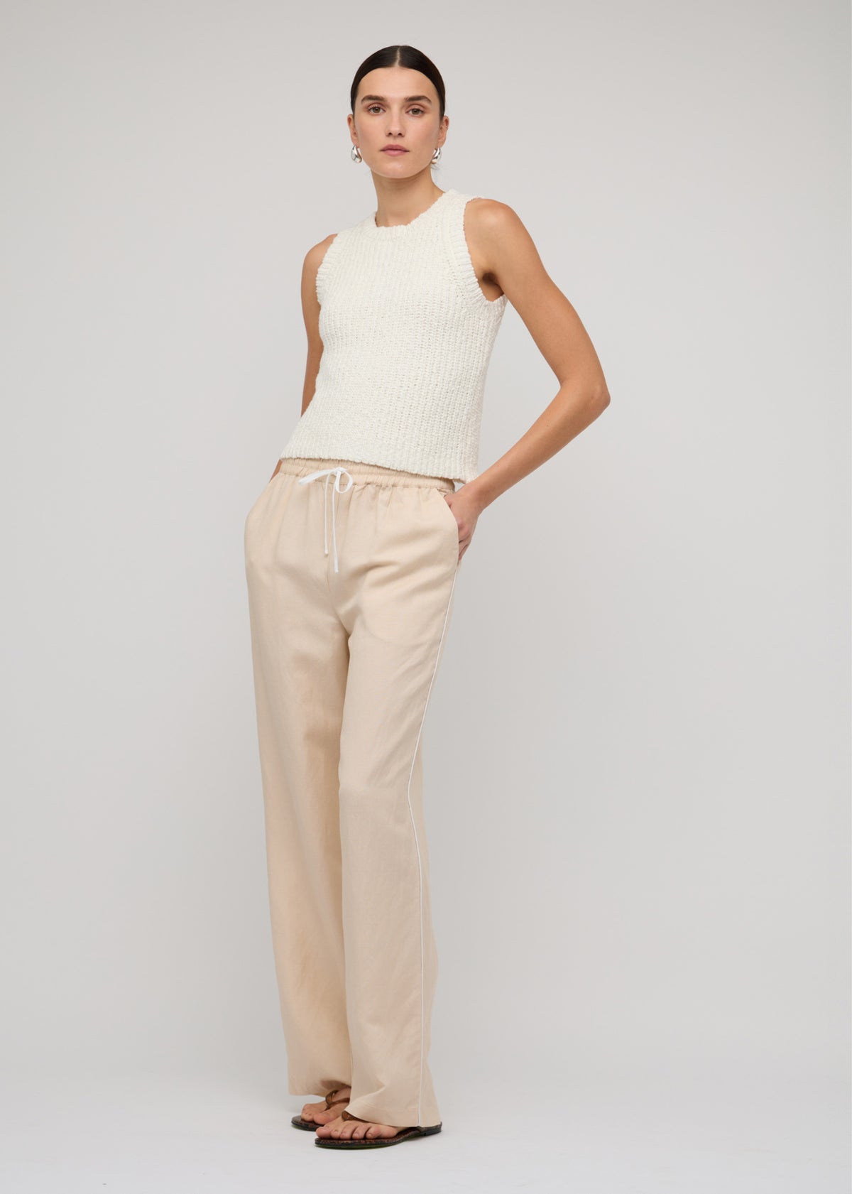 Model wearing Cotton-Blend Knit Tank Top In White with a crew neckline and a sleeveless cut.
