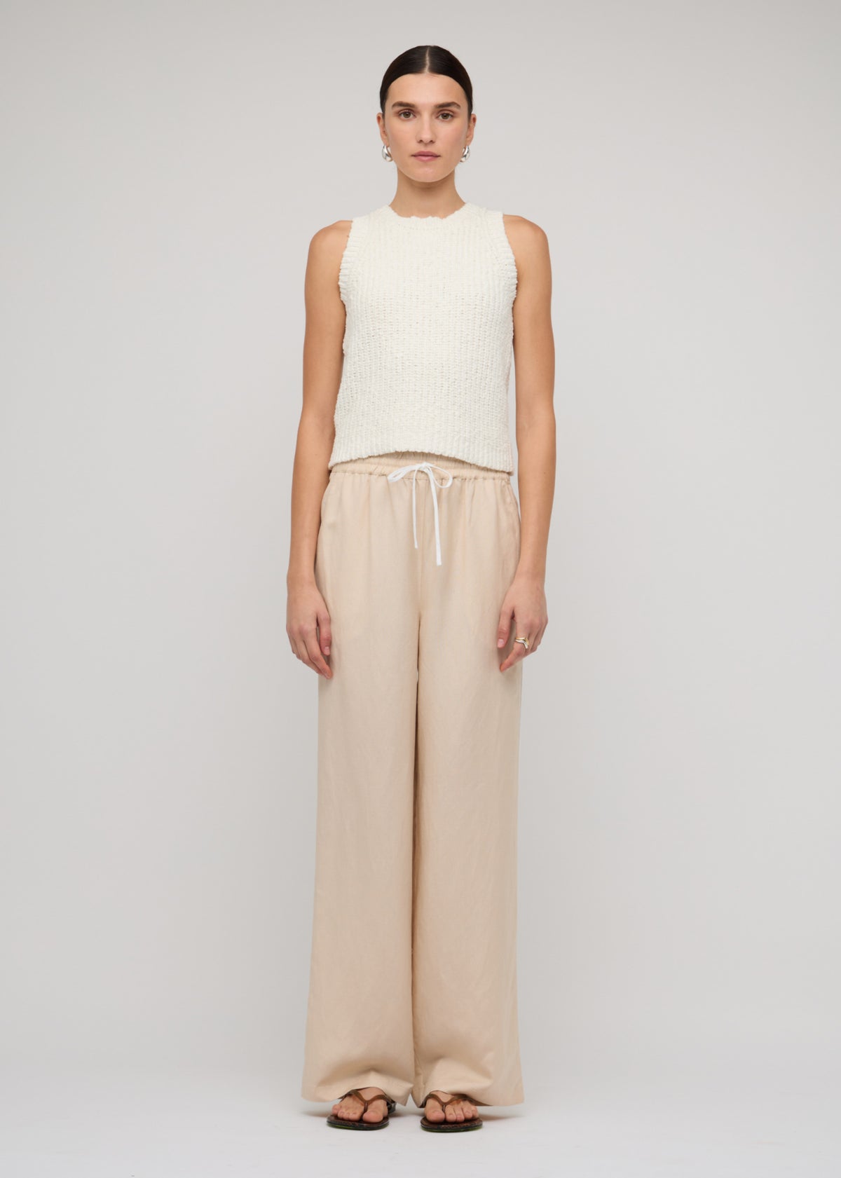 Model wearing Cotton-Blend Knit Tank Top In White, showing an ivory colour-way and a textured knit finish.