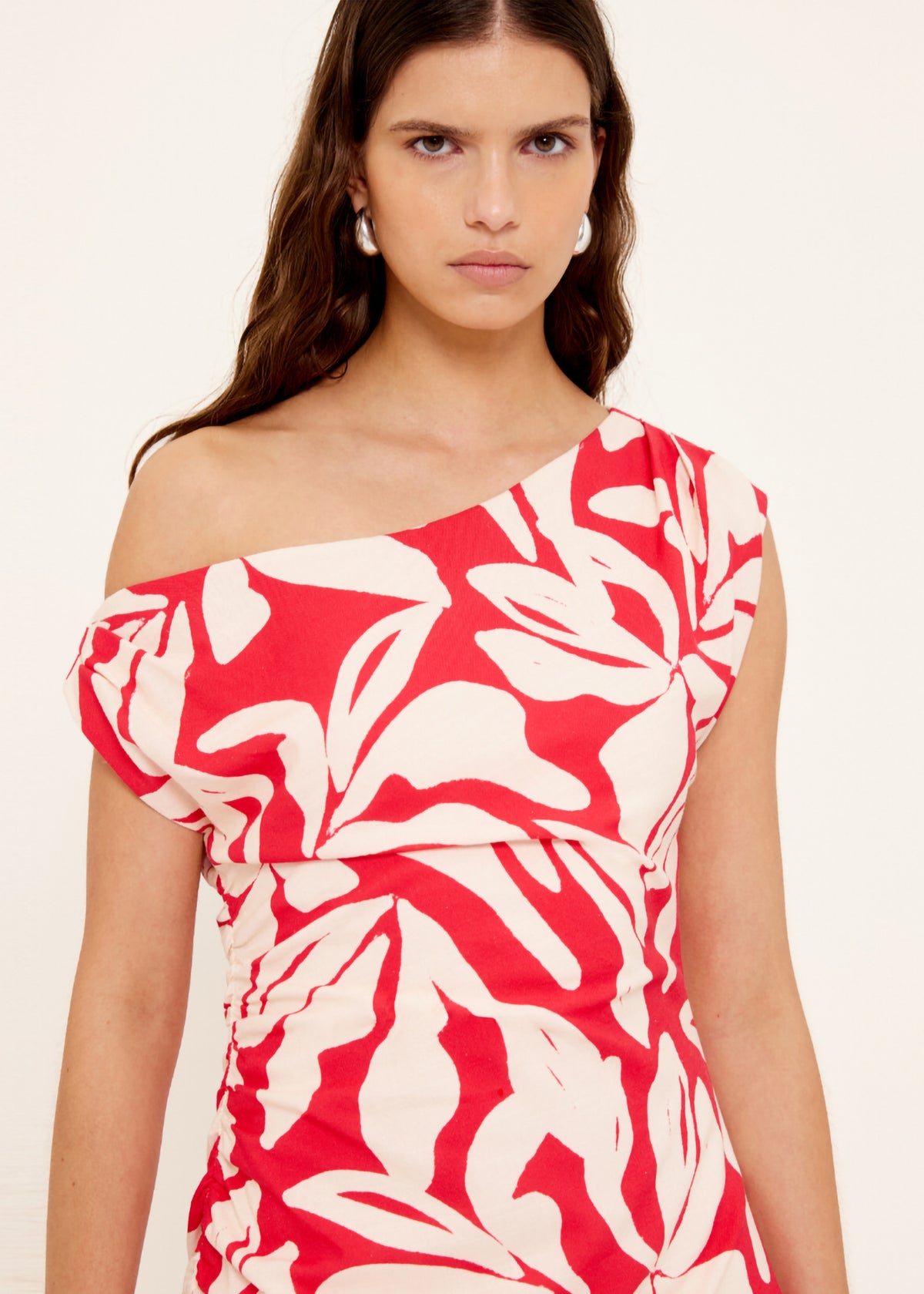 Close-up of Cotton Blend Red and White Floral Asymmetrical Midi Dress with a one-shoulder neckline with ruched detailing.