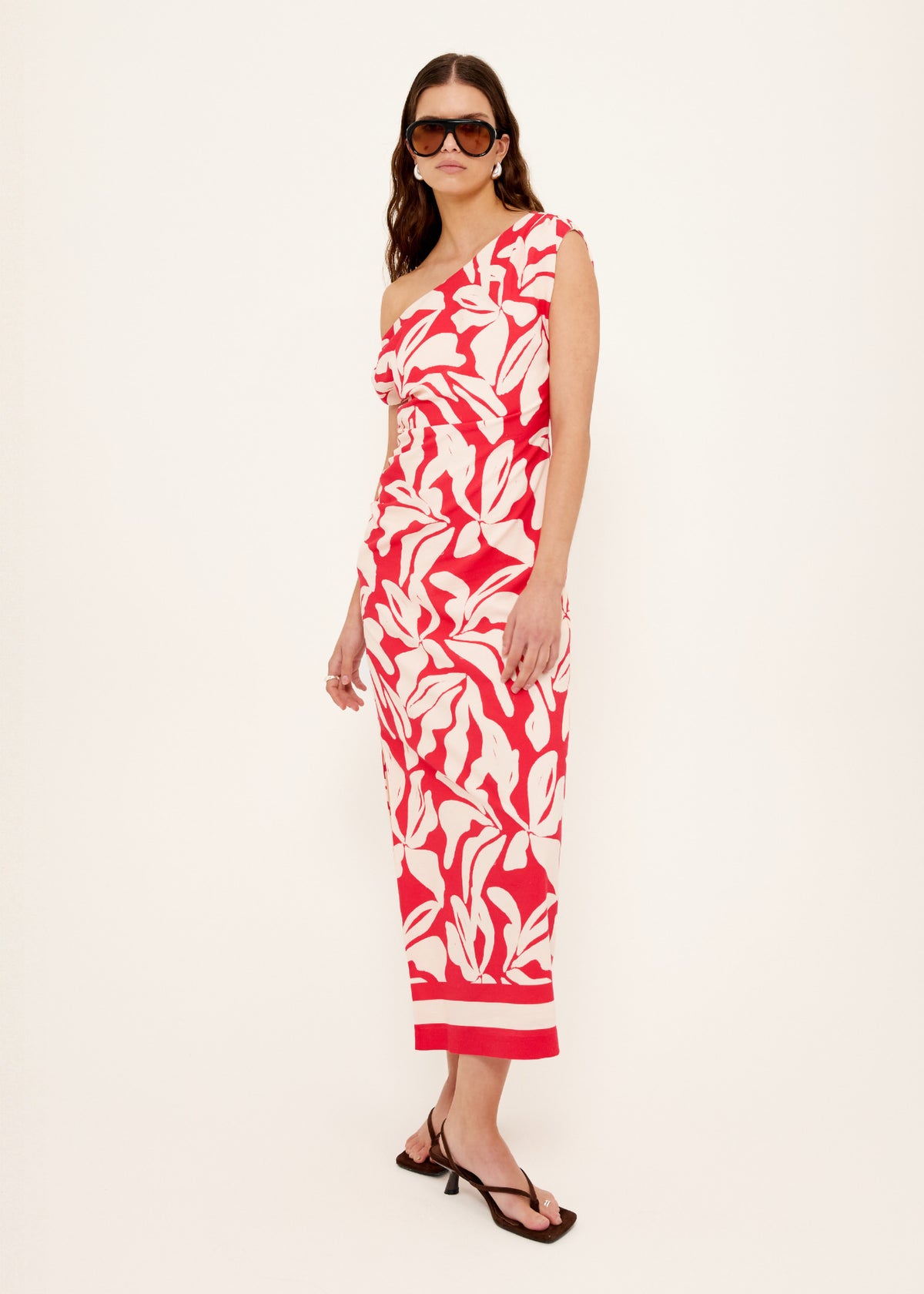 Model wearing Cotton Blend Red and White Floral Asymmetrical Midi Dress with a flattering fitted silhouette, turned to the side.