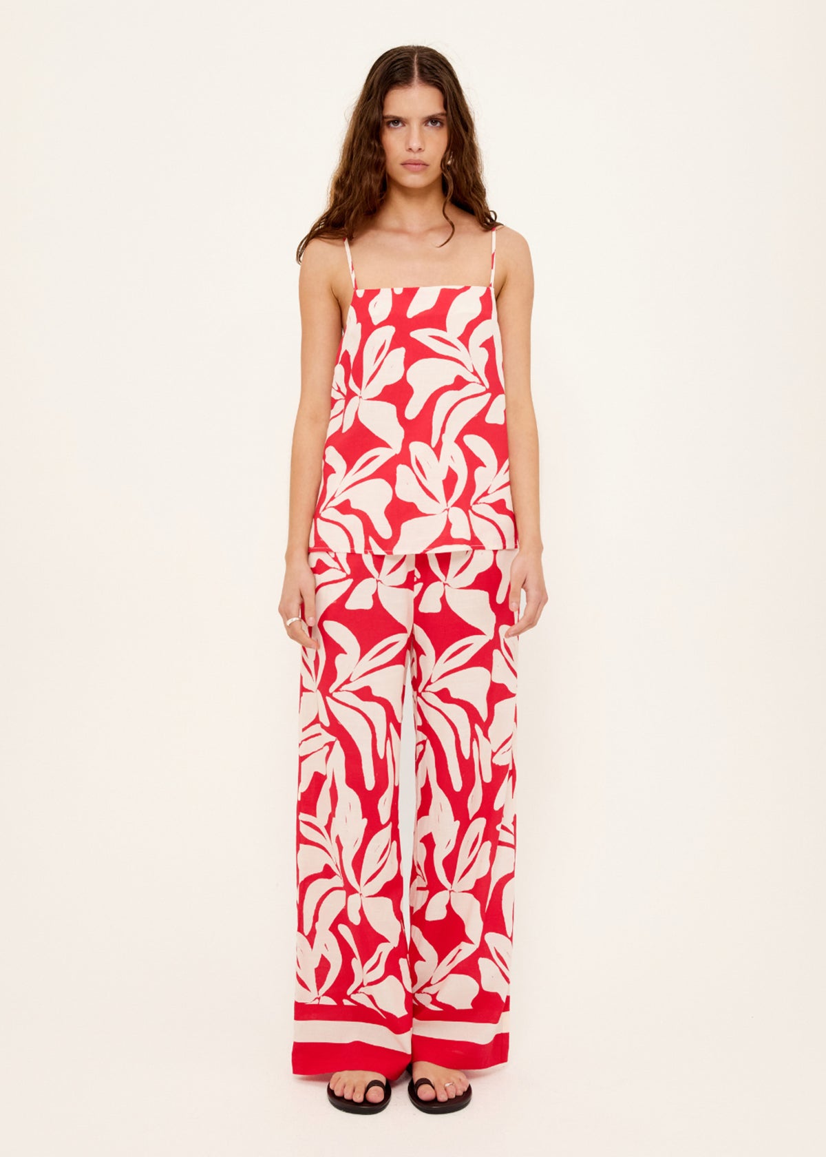 Model wearing Cotton Blend Red and White Floral Print Drawstring Pants, showing an exclusive Staple the Label print.