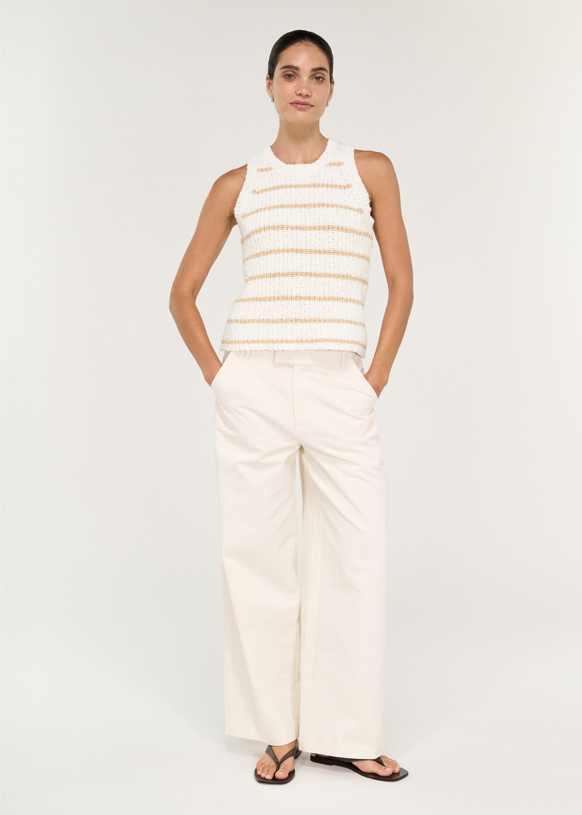 Model wearing Cotton Blend Stripe Knit Tank in White with a sleeveless silhouette and a round neckline.