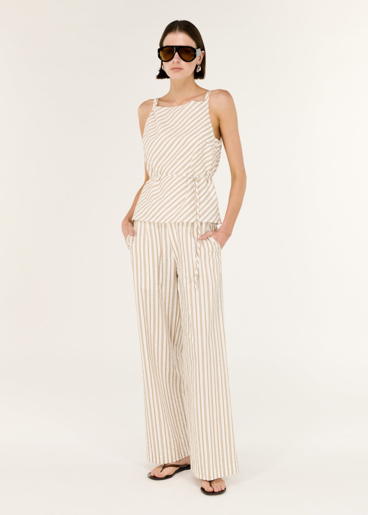 Model wearing Cotton Blend Stripe Mid-Rise Pants with a mid-rise waist and a relaxed wide-leg fit.