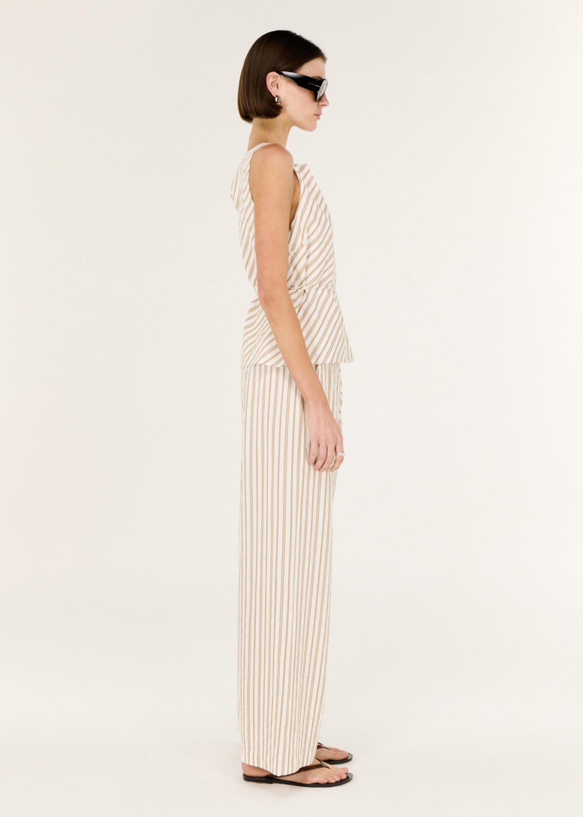 Model wearing Cotton Blend Stripe Mid-Rise Pants, showing a soft taupe and white stripe design.