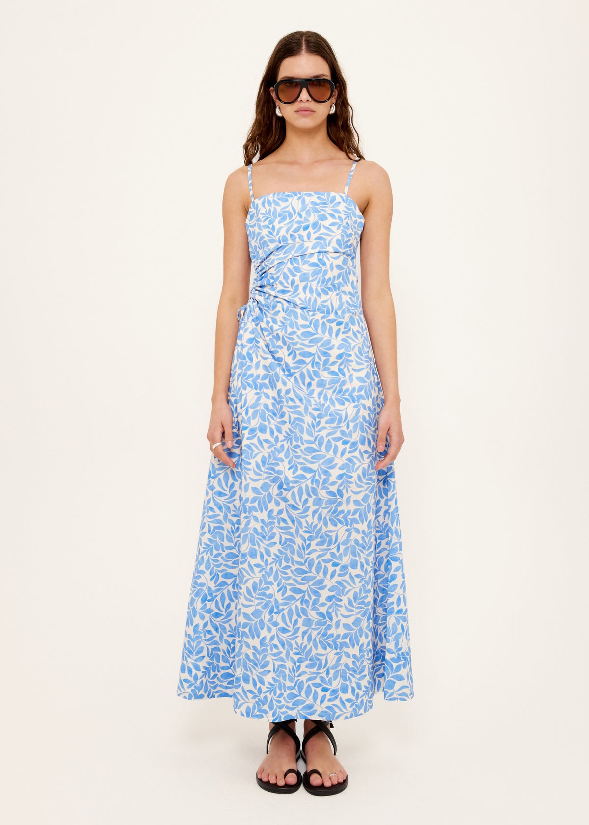 Model wearing Cotton Blue Leaf Print Cut Out Maxi Dress with square neckline with adjustable straps.