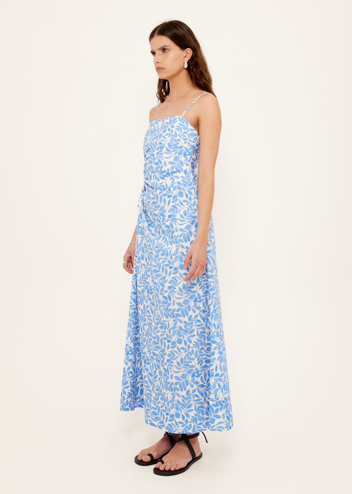 Side profile of the Cotton Blue Leaf Print Cut Out Maxi Dress with a ruched waist with side cut-out detail.