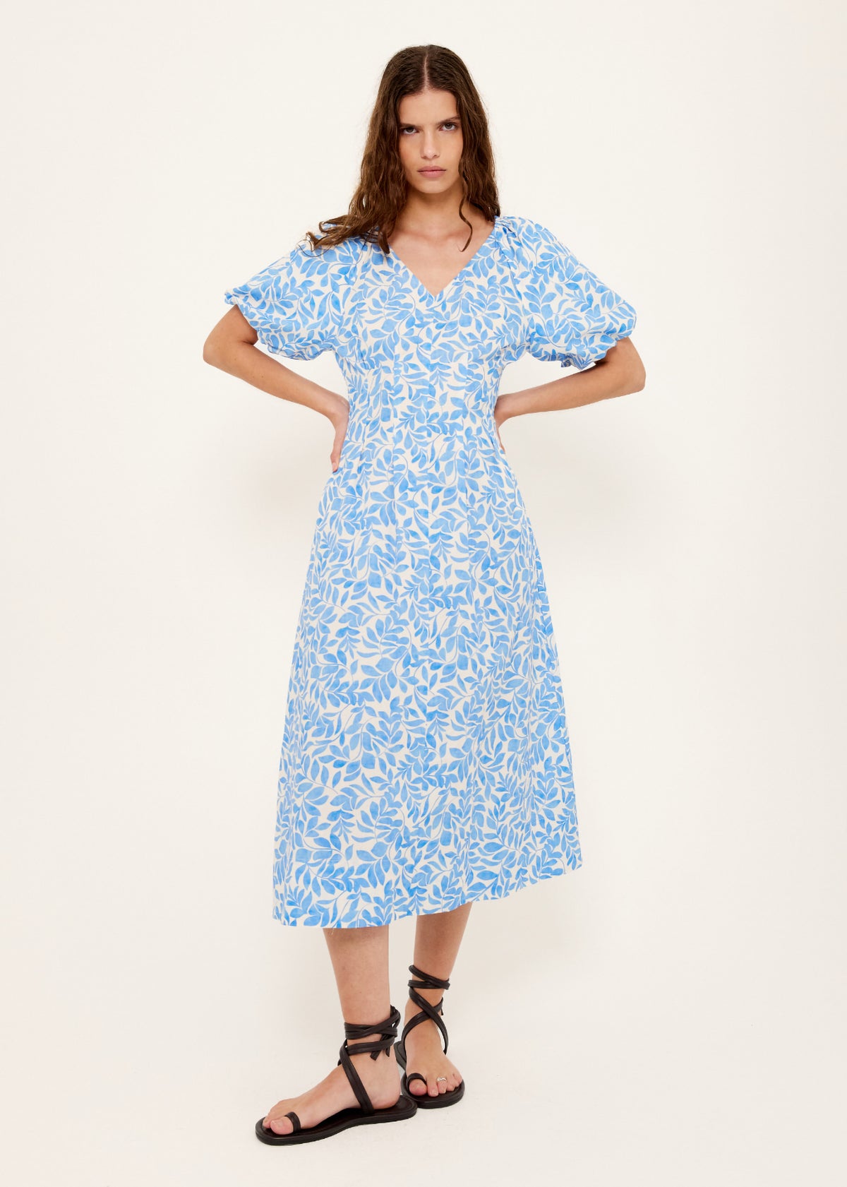 Model wearing Cotton Blue Leaf Print V-neck Midi Dress, showing an exclusive blue and ivory print.
