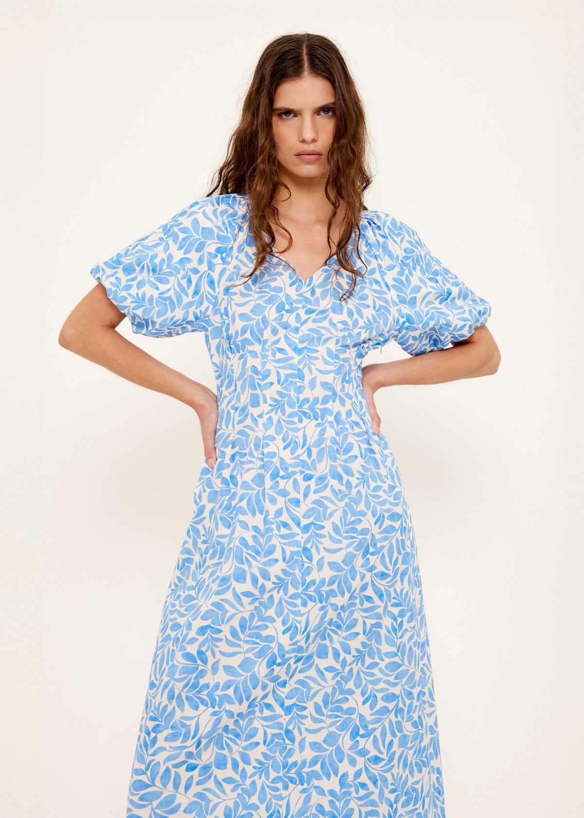 Model wearing Cotton Blue Leaf Print V-neck Midi Dress with an exclusive blue and ivory print and a fully lined.