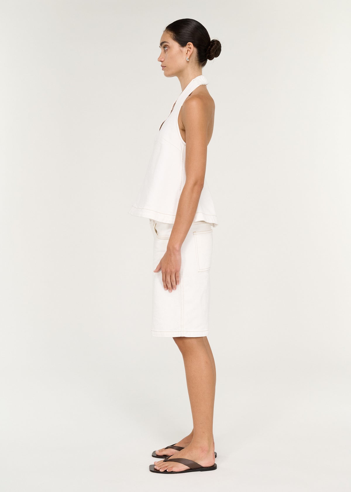 Side view of the Cotton Denim Halter Top in White, showing a halter neckline and a deep V-neckline.