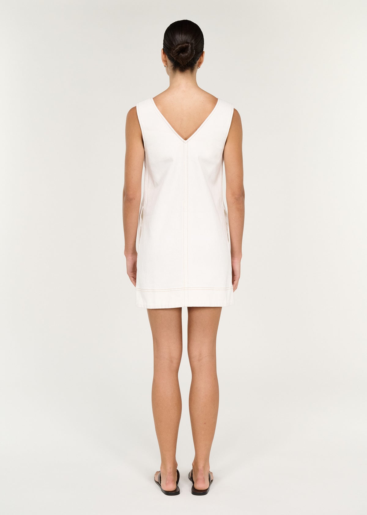 Back view of the Cotton Denim Mini Shift Dress in White with a v-neckline at front and back.