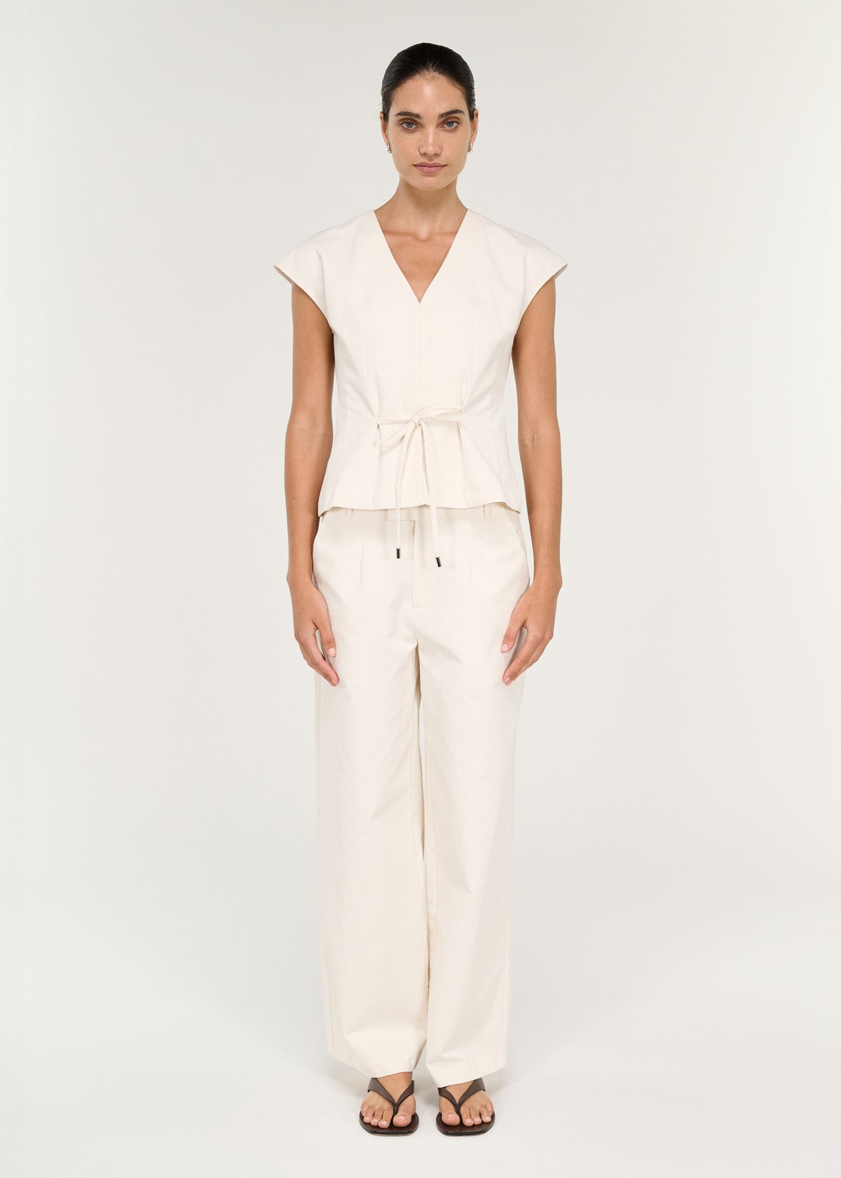 Model wearing Cotton Tie Front Top with Cap Sleeve with a self-fabric tie front detail and metal-tipped ties.