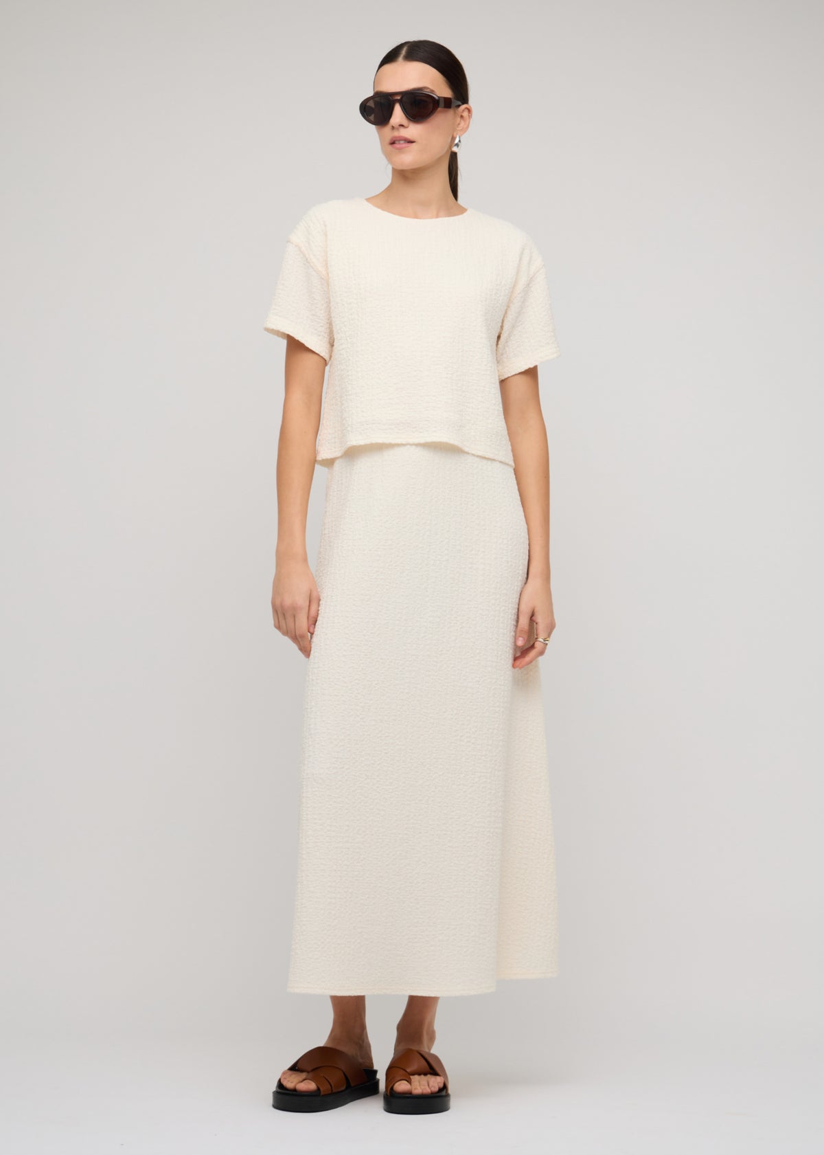Model wearing Cream A-Line Midi Skirt with a midi length (front full body).