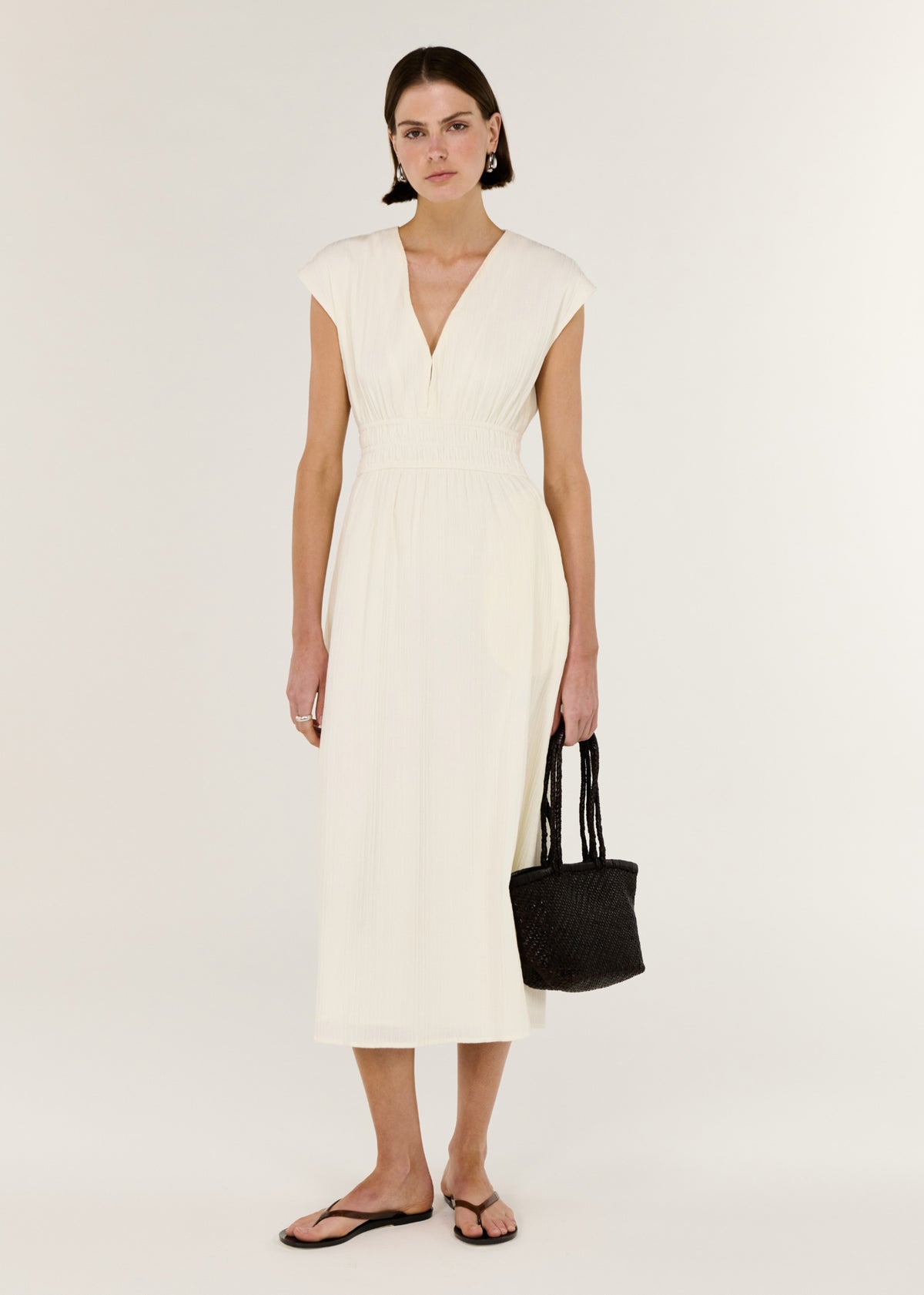 Model wearing Cream Cotton V-Neck Midi Dress with soft cap sleeves and a defined waist with gentle gathering.