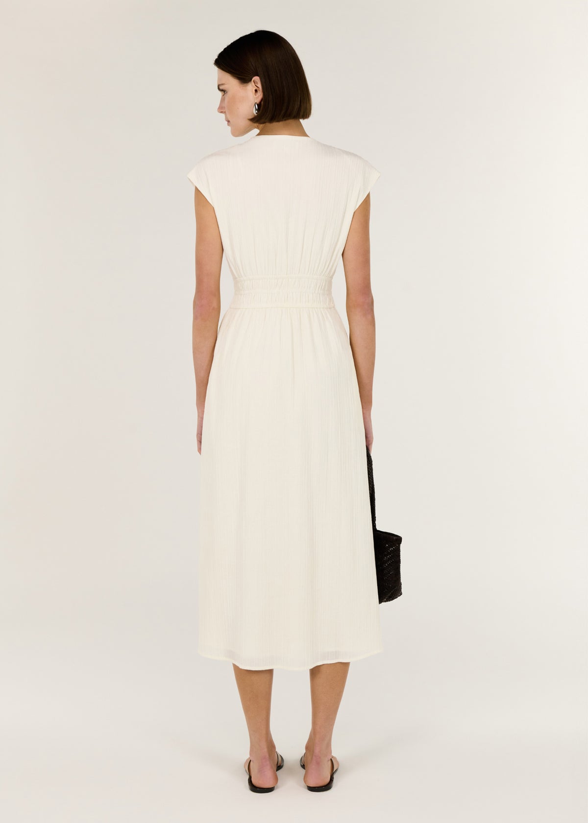 Back view of the Cream Cotton V-Neck Midi Dress with soft cap sleeves and a defined waist with gentle gathering.