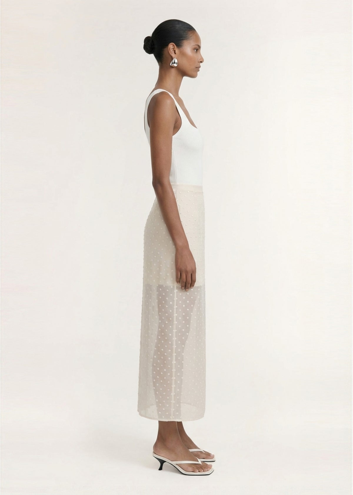 Side view of the Cream Embroidered Spot Sheer Layered Midi Skirt, showing a midi length and a back zip closure.