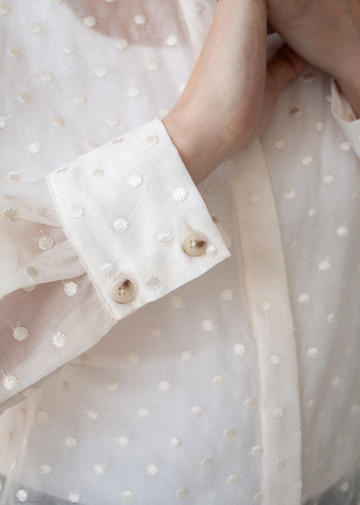 Close-up detail of the Cream Embroidered Spot Sheer Oversized Shirt, showing cuff button.