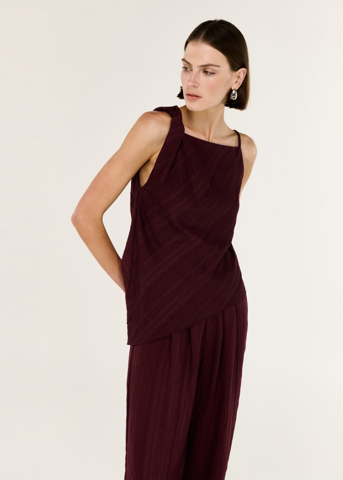 Close-up of Deep Red Textured Wide-Leg Pant with a high-rise waist and a wide leg silhouette.
