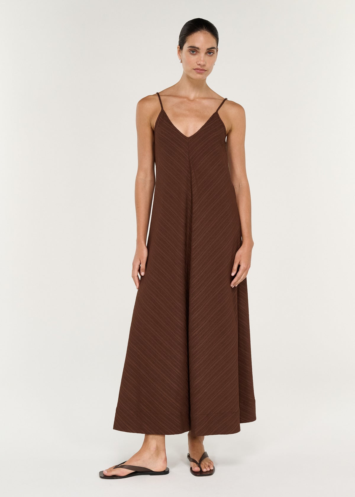 Textured Maxi Dress in Chocolate featuring a V-neckline and thin straps, designed with a flowing full skirt.