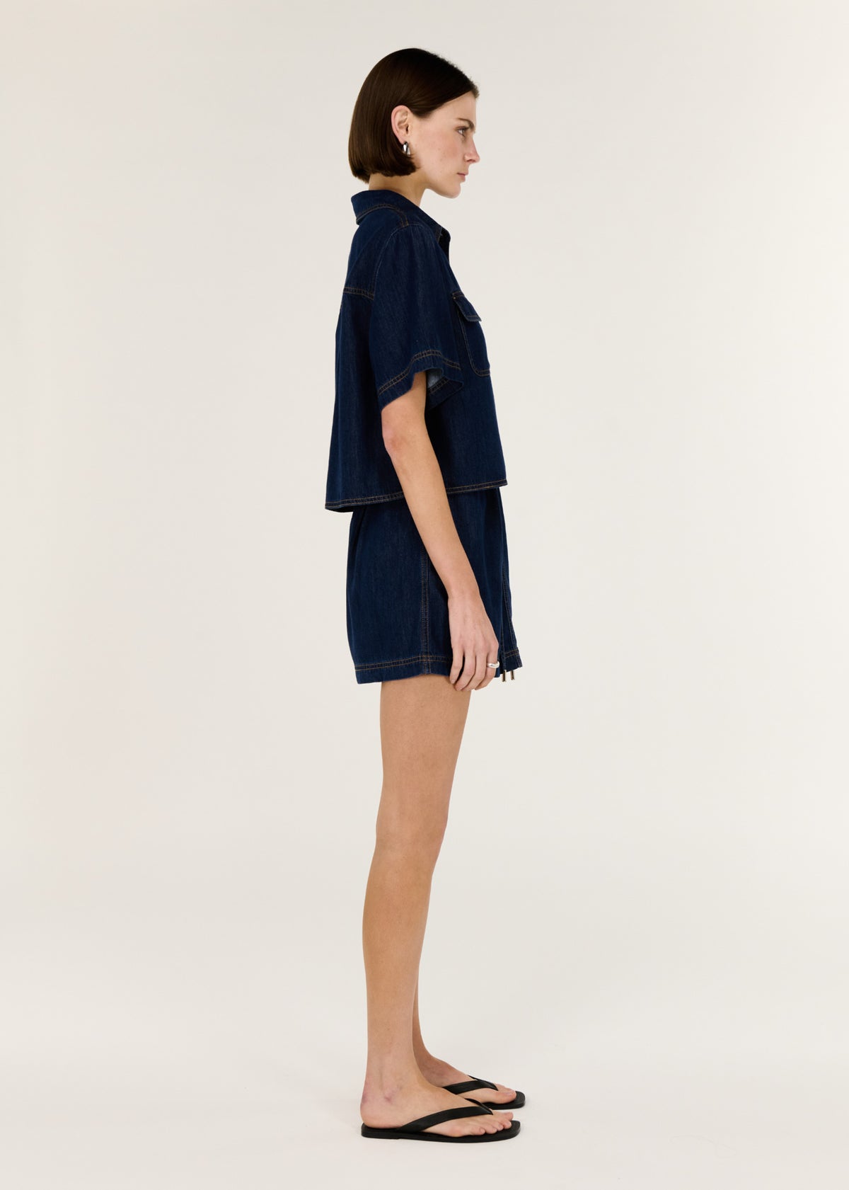 Side view of the Denim Cropped Short-Sleeve Shirt, showing short sleeves and a button-through front.