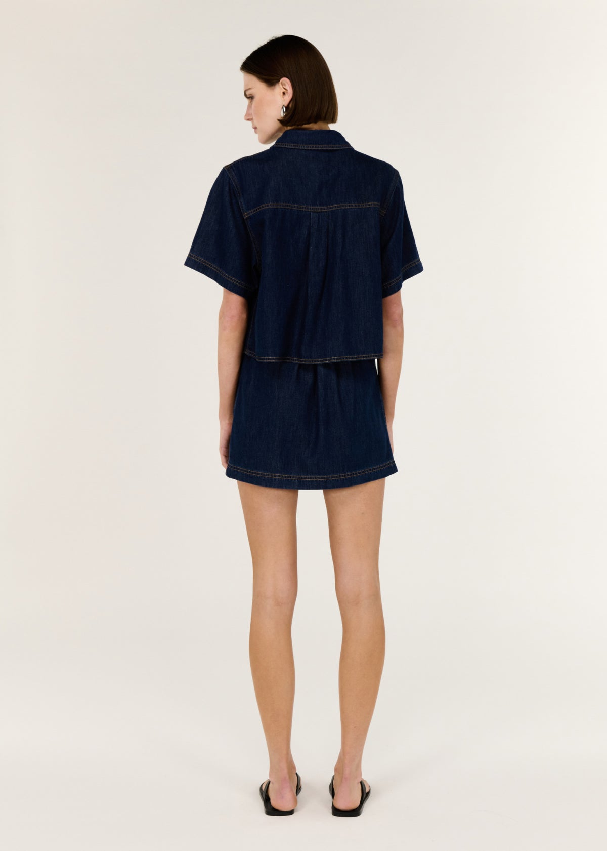 Back view of the Denim Cropped Short-Sleeve Shirt with a button-through front and short sleeves.