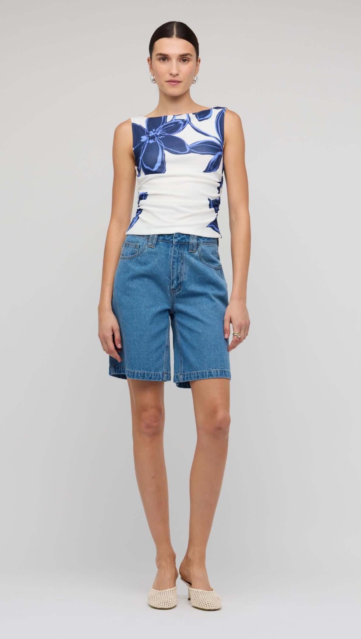 Model wearing Denim Mid-Rise Shorts paired with a floral top for a stylish summer look.