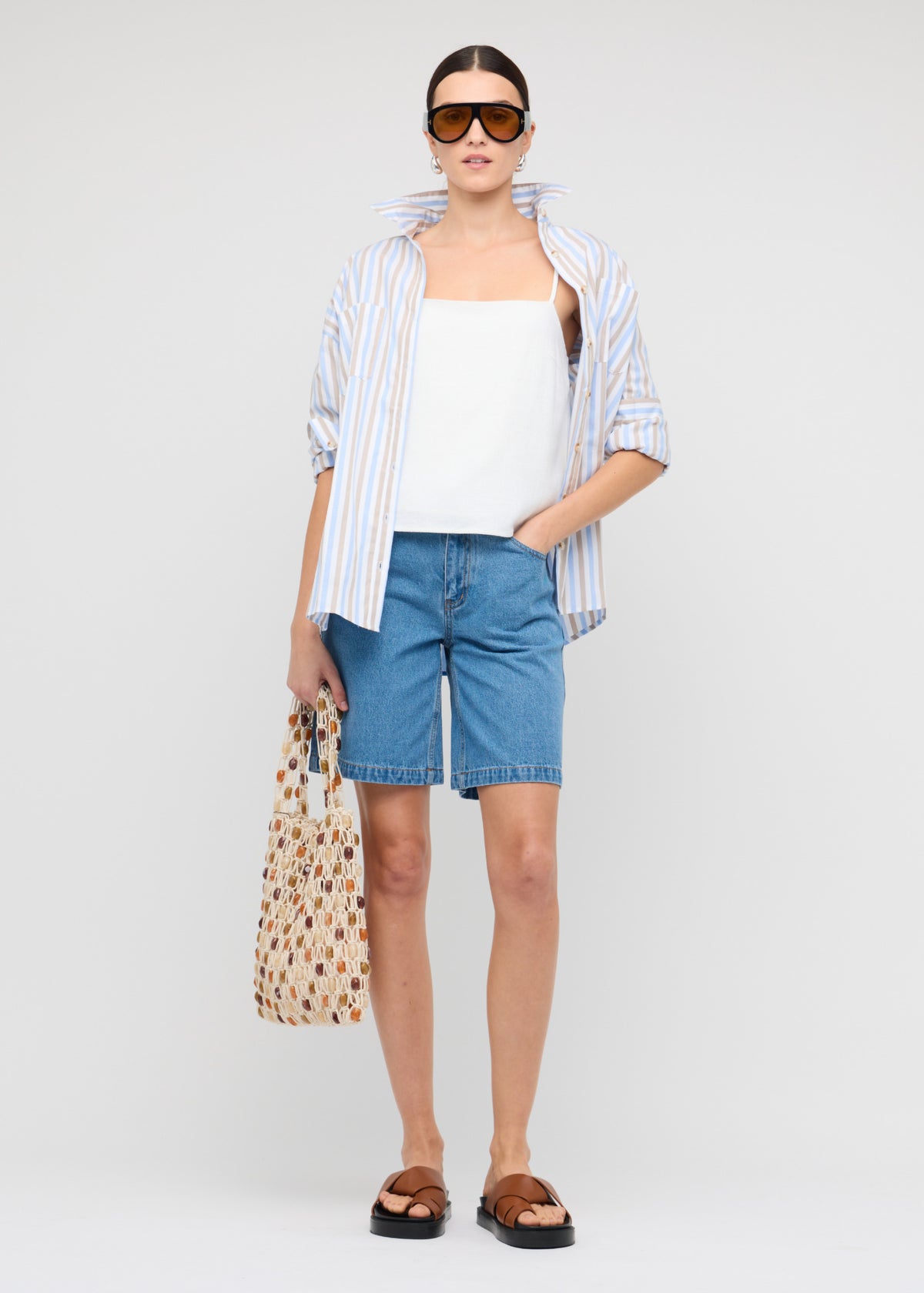 Model wearing Denim Mid-Rise Shorts with a mid-rise fit and a relaxed straight-leg silhouette.