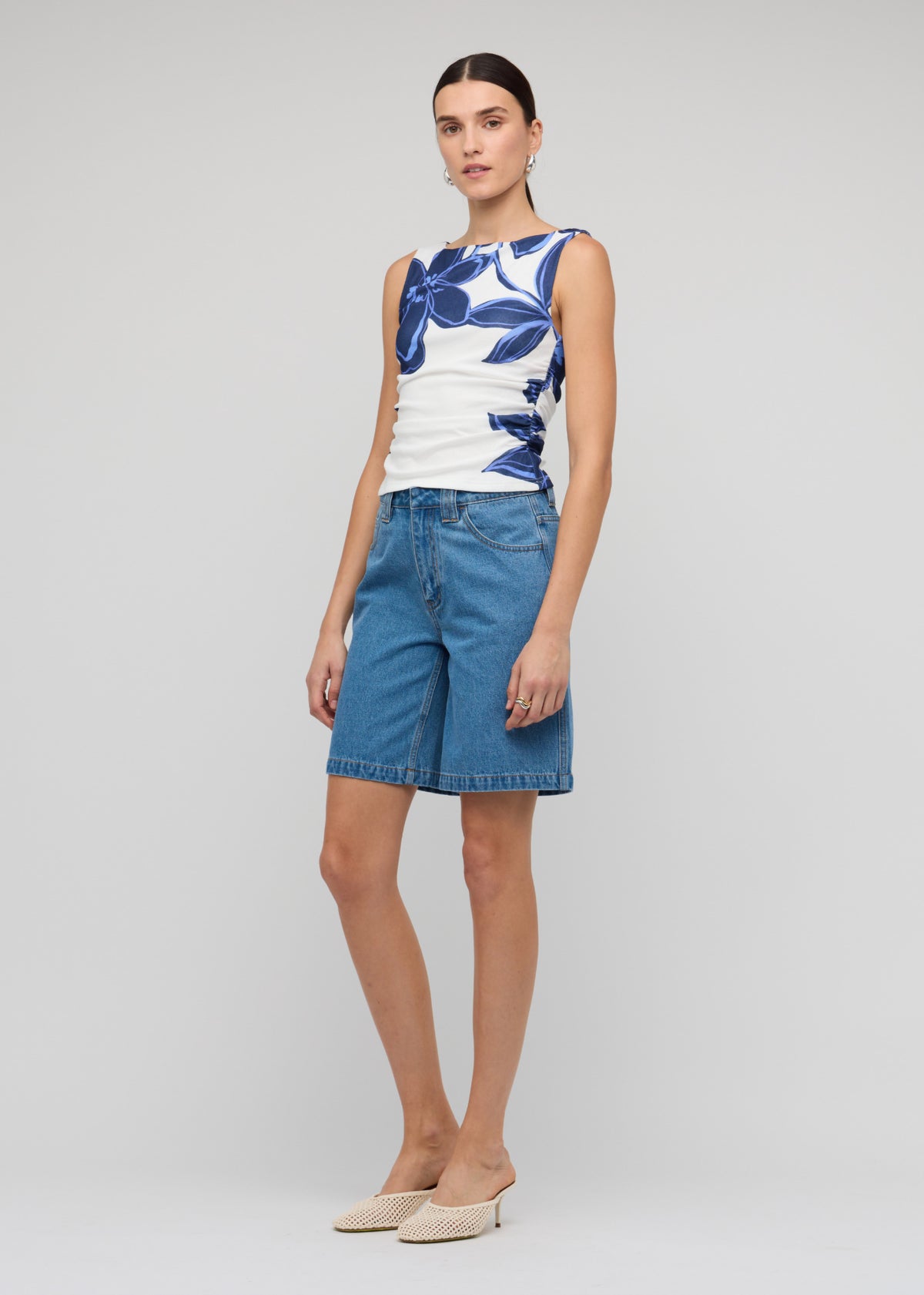 Side view of the Denim Mid-Rise Shorts, showing a mid-rise fit and a relaxed straight-leg silhouette.