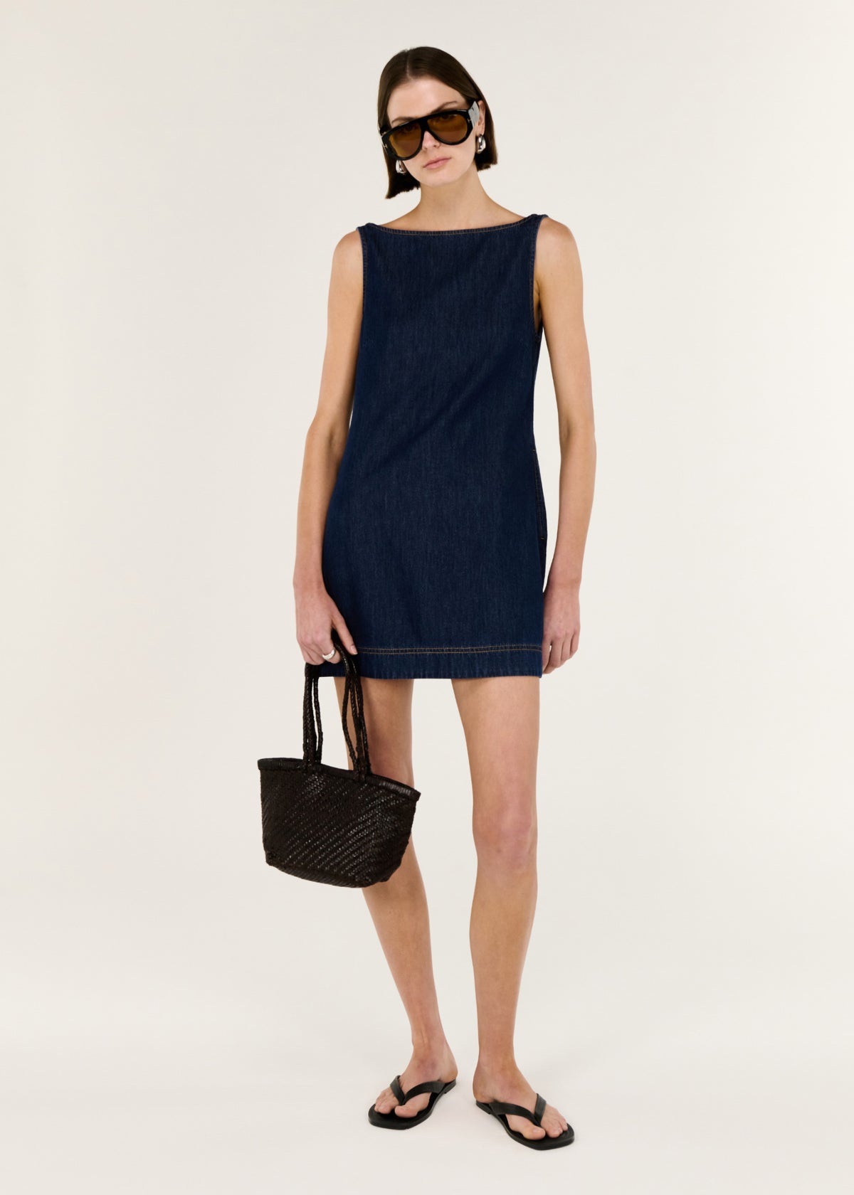 Model wearing Denim Mini Dress with Scoop Back with a soft, lightweight denim feel and an easy pull-on style, turned to the side.