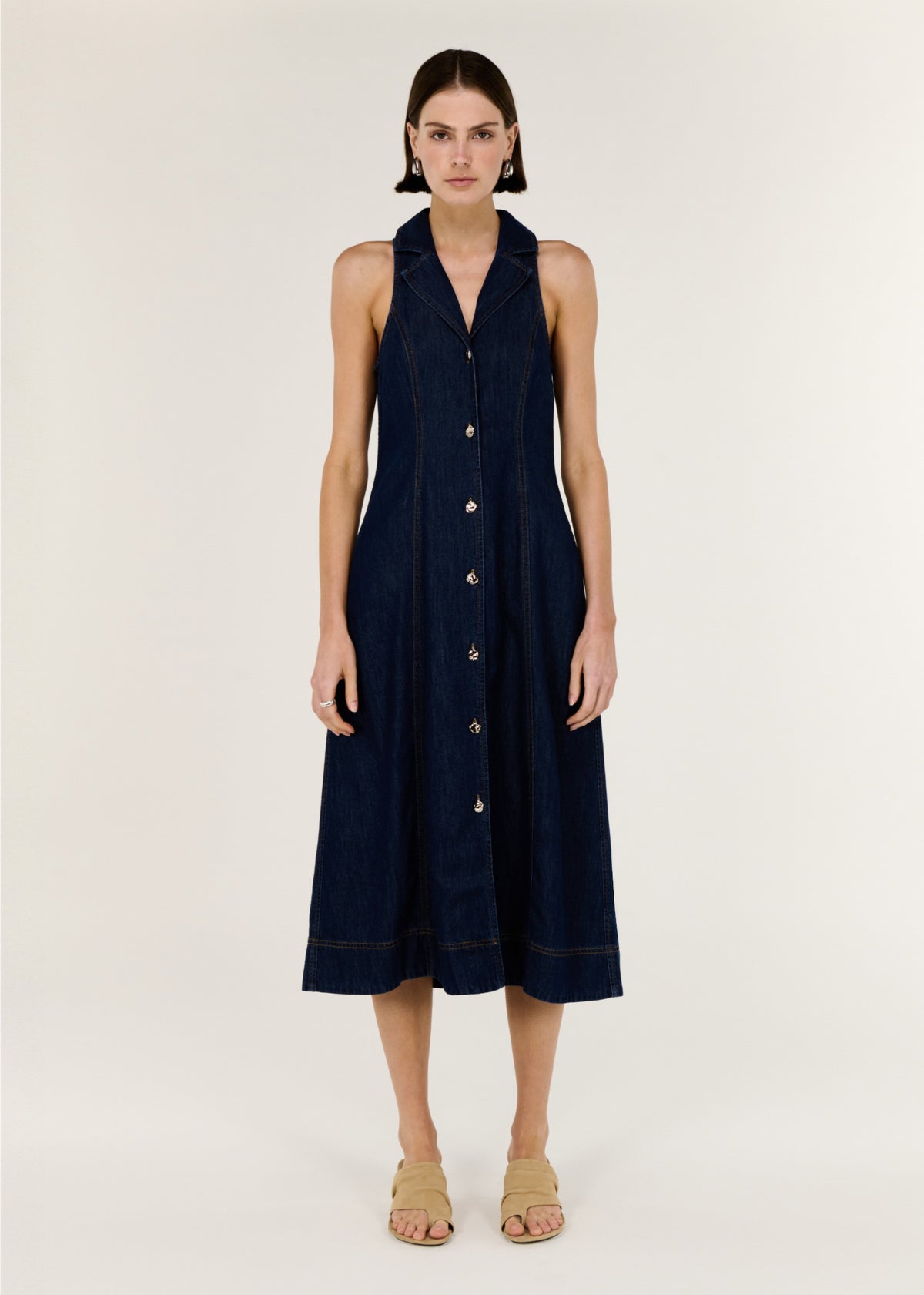 Model wearing Denim Sleeveless Midi Shirt Dress with a structured indigo denim and a sleeveless cut.