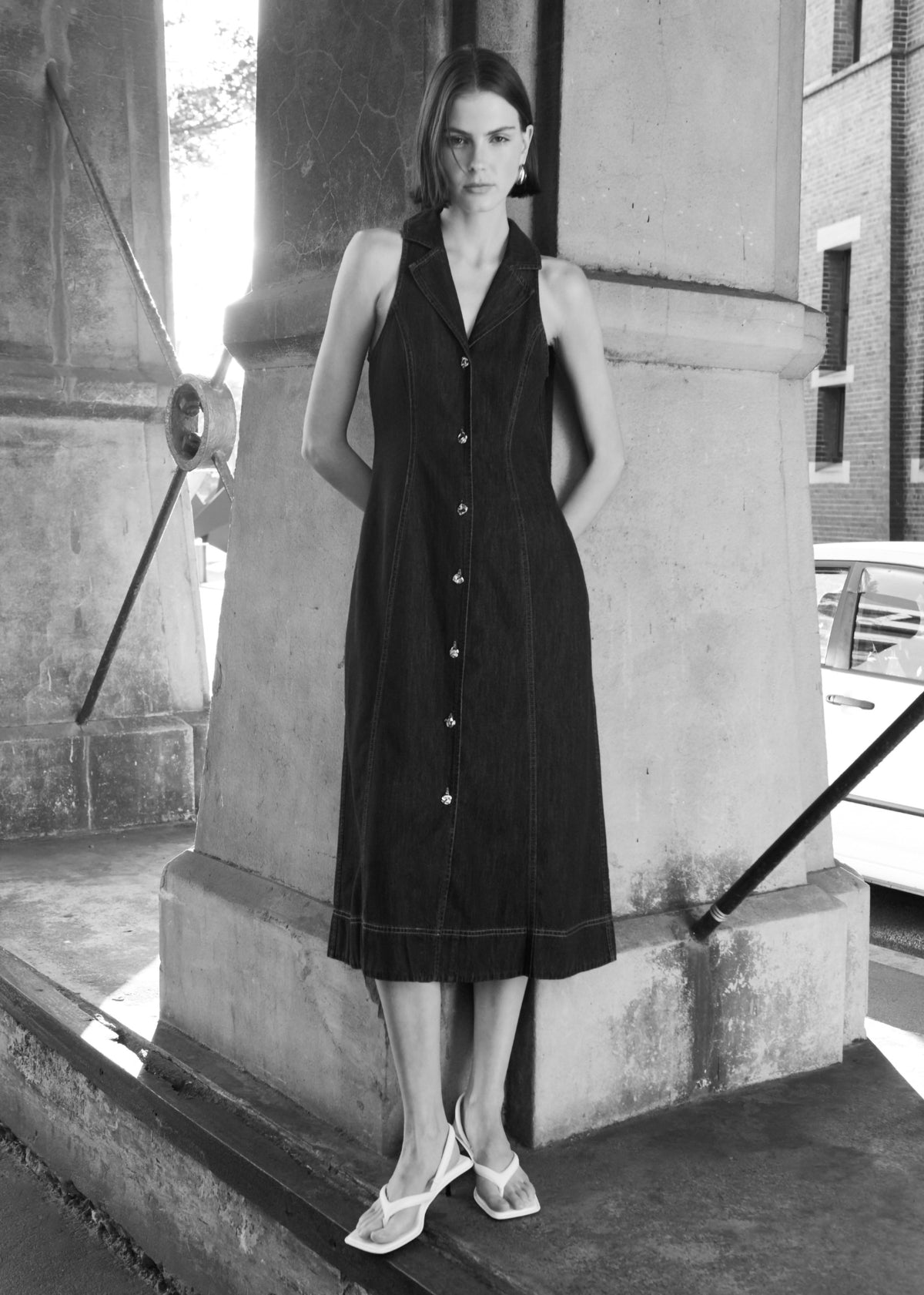 Model wearing Denim Sleeveless Midi Shirt Dress with a midi length and a flattering A-line silhouette, turned to the side.