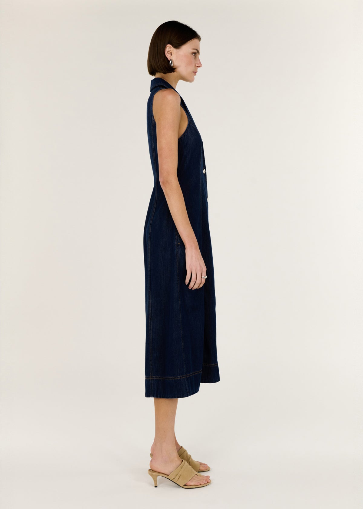 Side view of the Denim Sleeveless Midi Shirt Dress, showing a flattering A-line silhouette and functional side pockets.