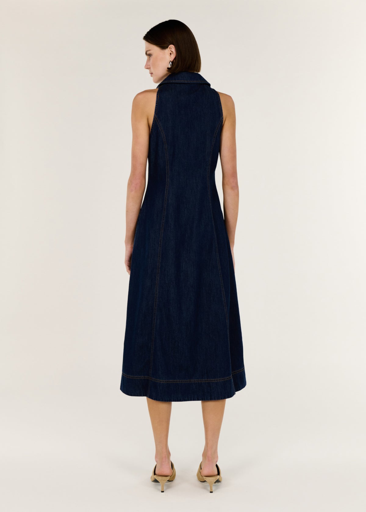 Back view of the Denim Sleeveless Midi Shirt Dress with a button-through front and a structured indigo denim.