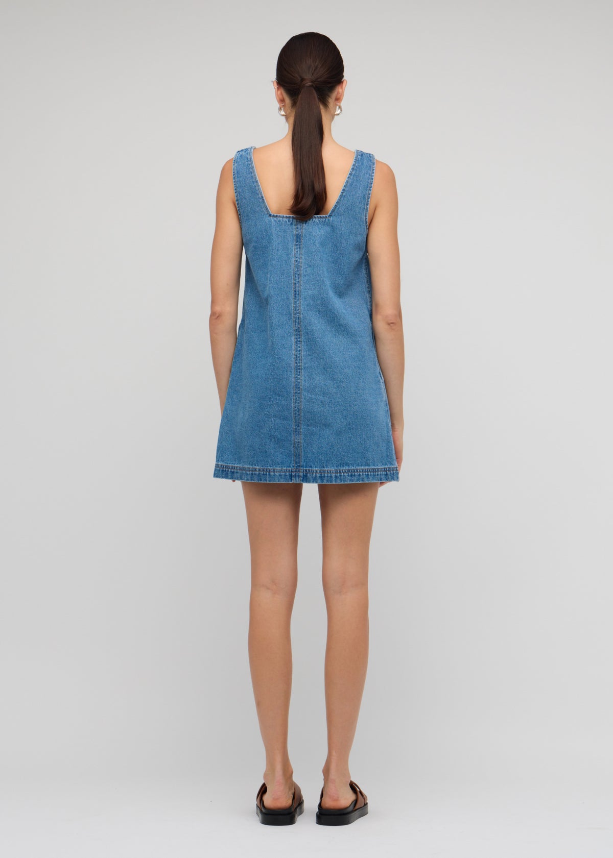 Back view of the Denim Square Neck Mini Dress with a sleeveless cut and a relaxed A-line fit.