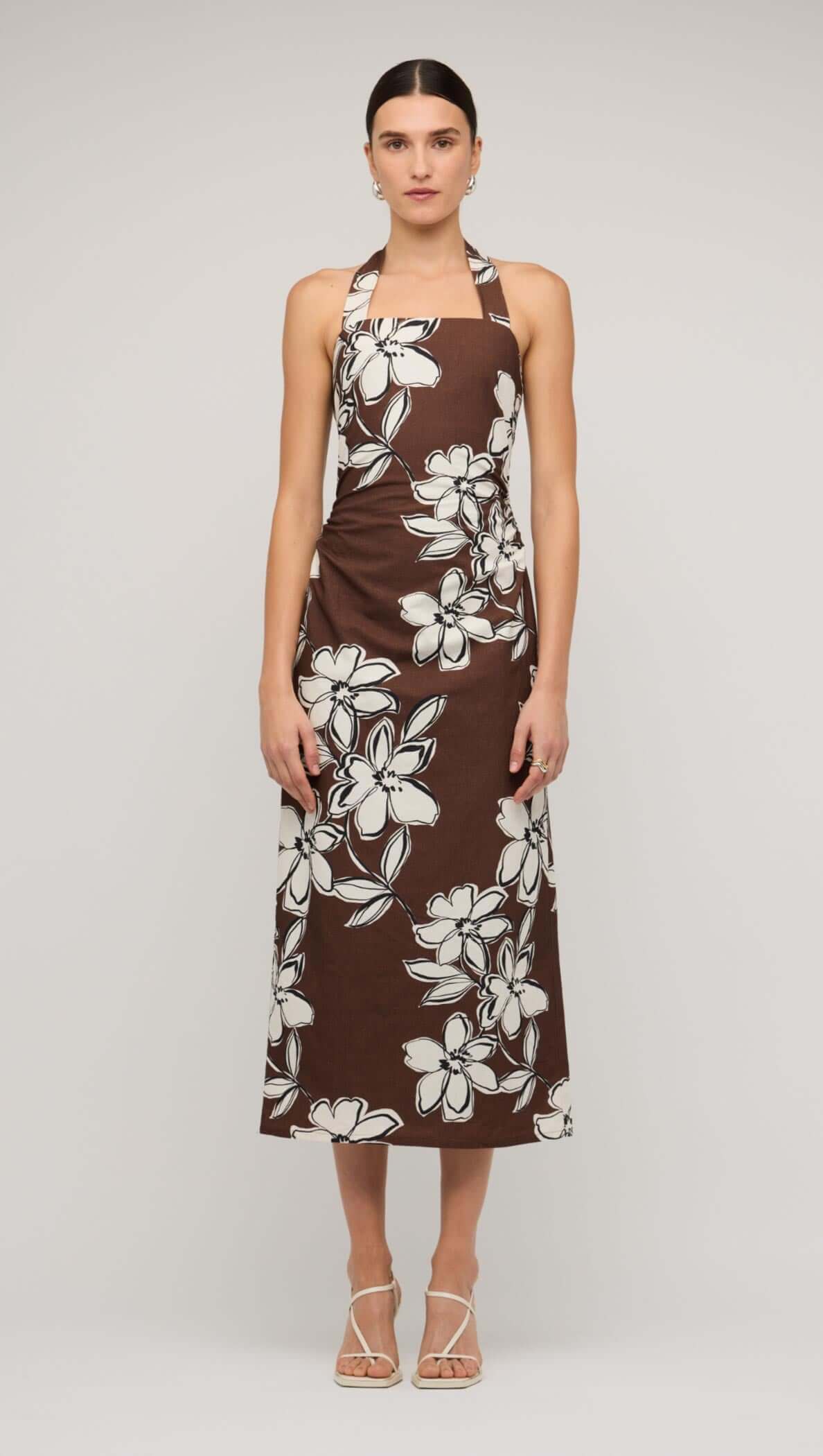 Brown and white floral halter-neck midi dress on model, showcasing elegant design and comfortable fit.