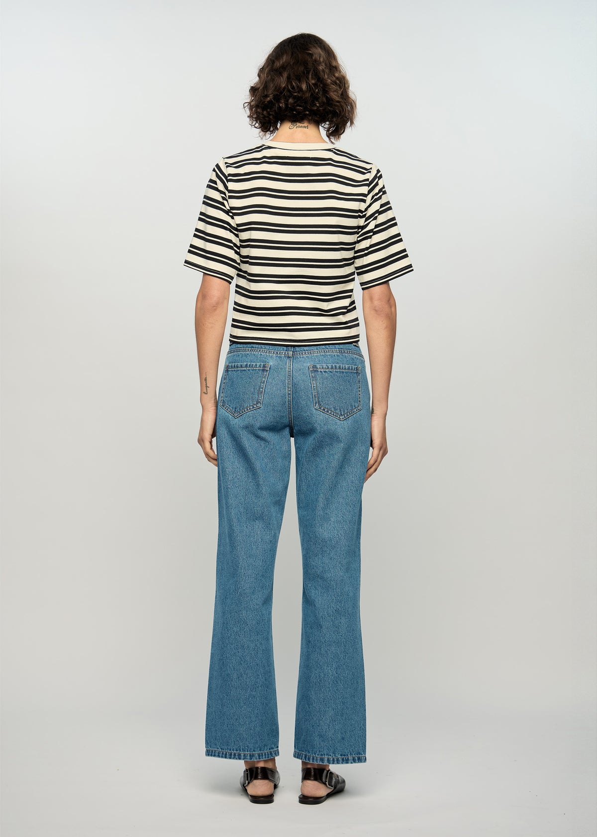 Back view of the Elara Crop Tee with a black and ivory stripe pattern.