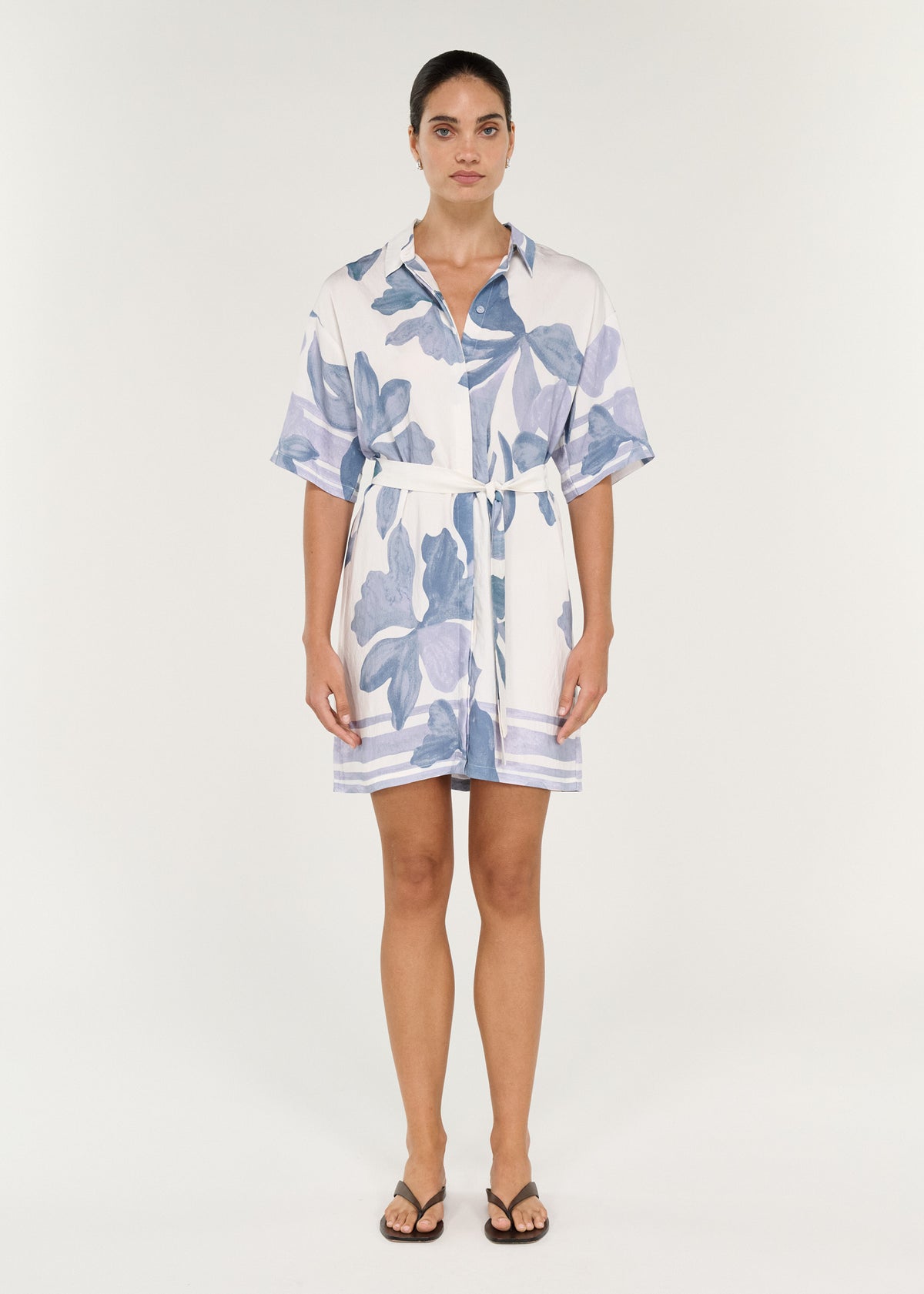 Model wearing Mini Shirtdress in Blue Floral with oversized fit, self-tie waist, and floral print design.