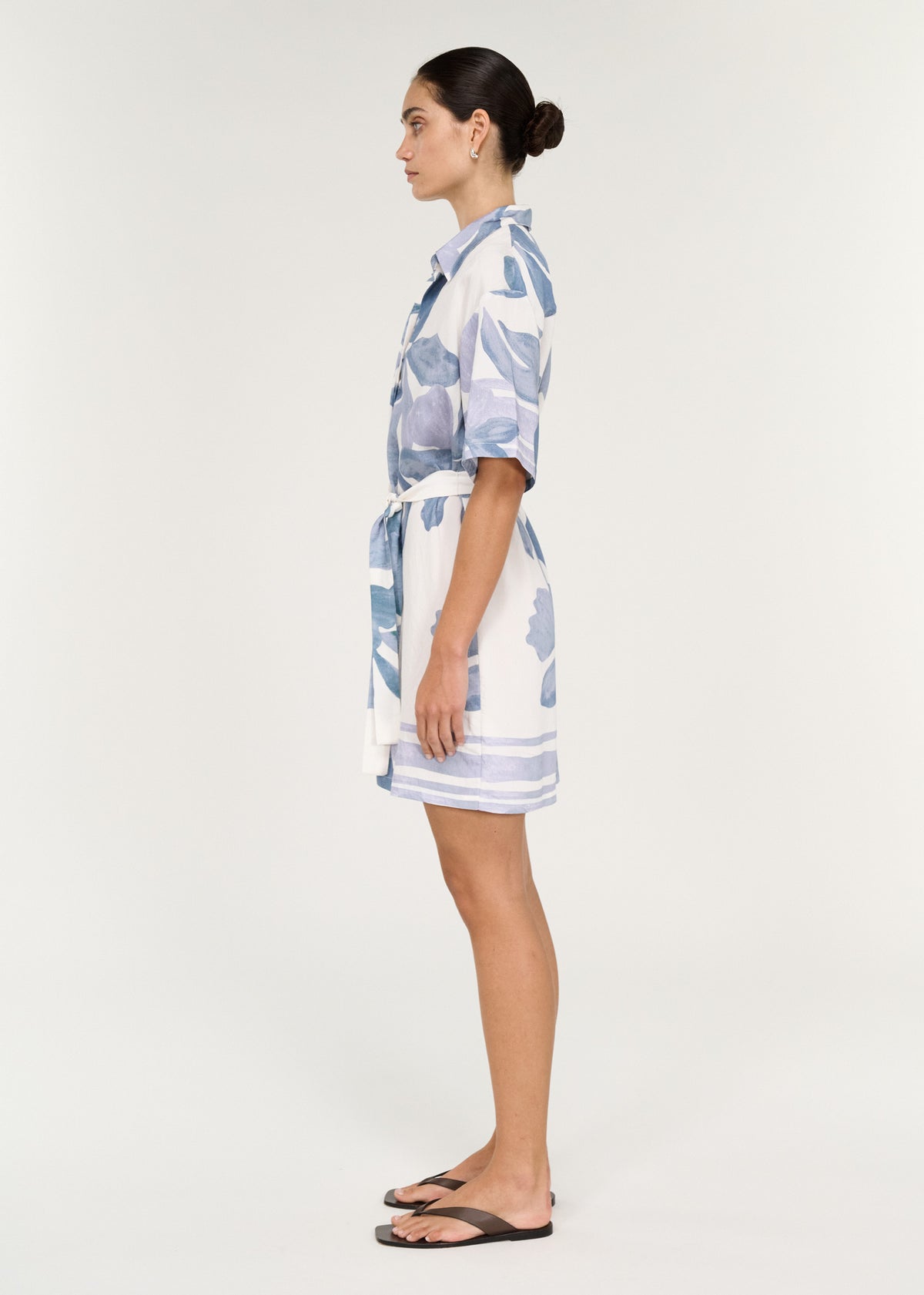 Model wearing a Mini Shirtdress in Blue Floral, showcasing the collared neckline and self-tie waist belt in profile view.