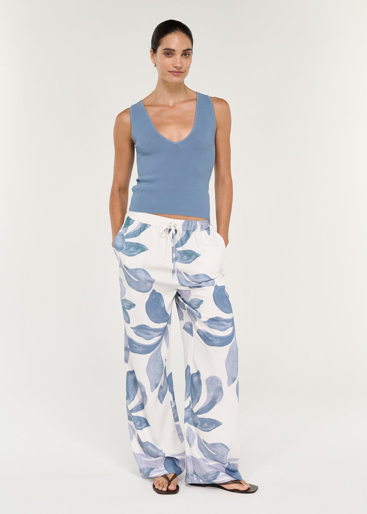 Model wearing Relaxed Drawstring Pant in Blue Floral with a blue top and sandals, showcasing a casual summer outfit.
