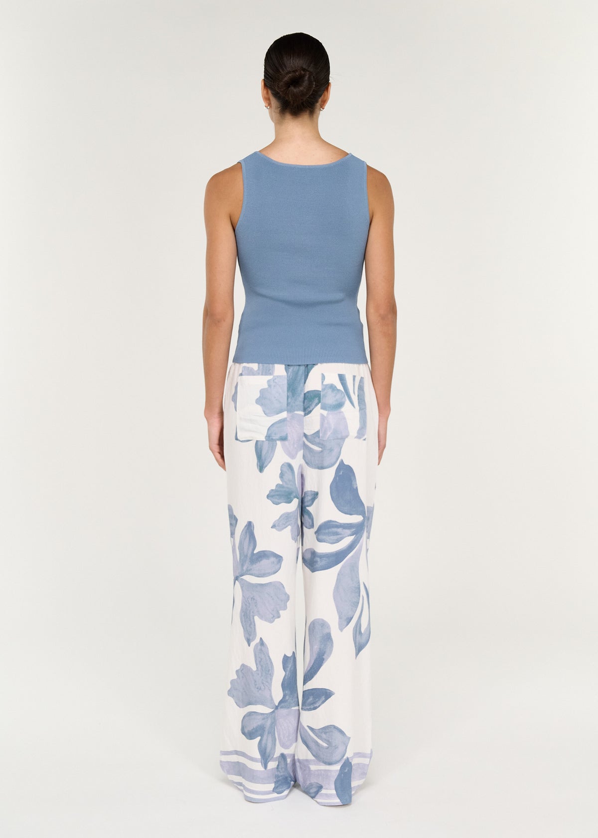 Model wearing Relaxed Drawstring Pant in Blue Floral and blue tank top from the back.