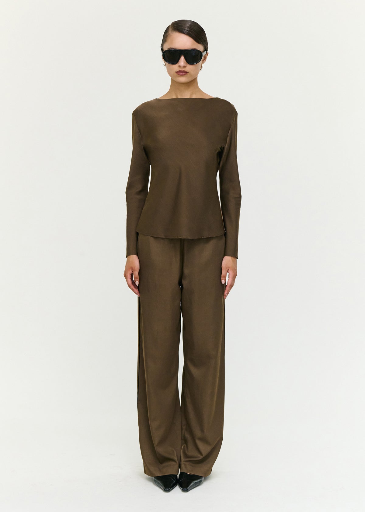 Model wearing Espresso Relaxed Cut Silky Pant with a soft woven fabrication and a relaxed wide leg silhouette.