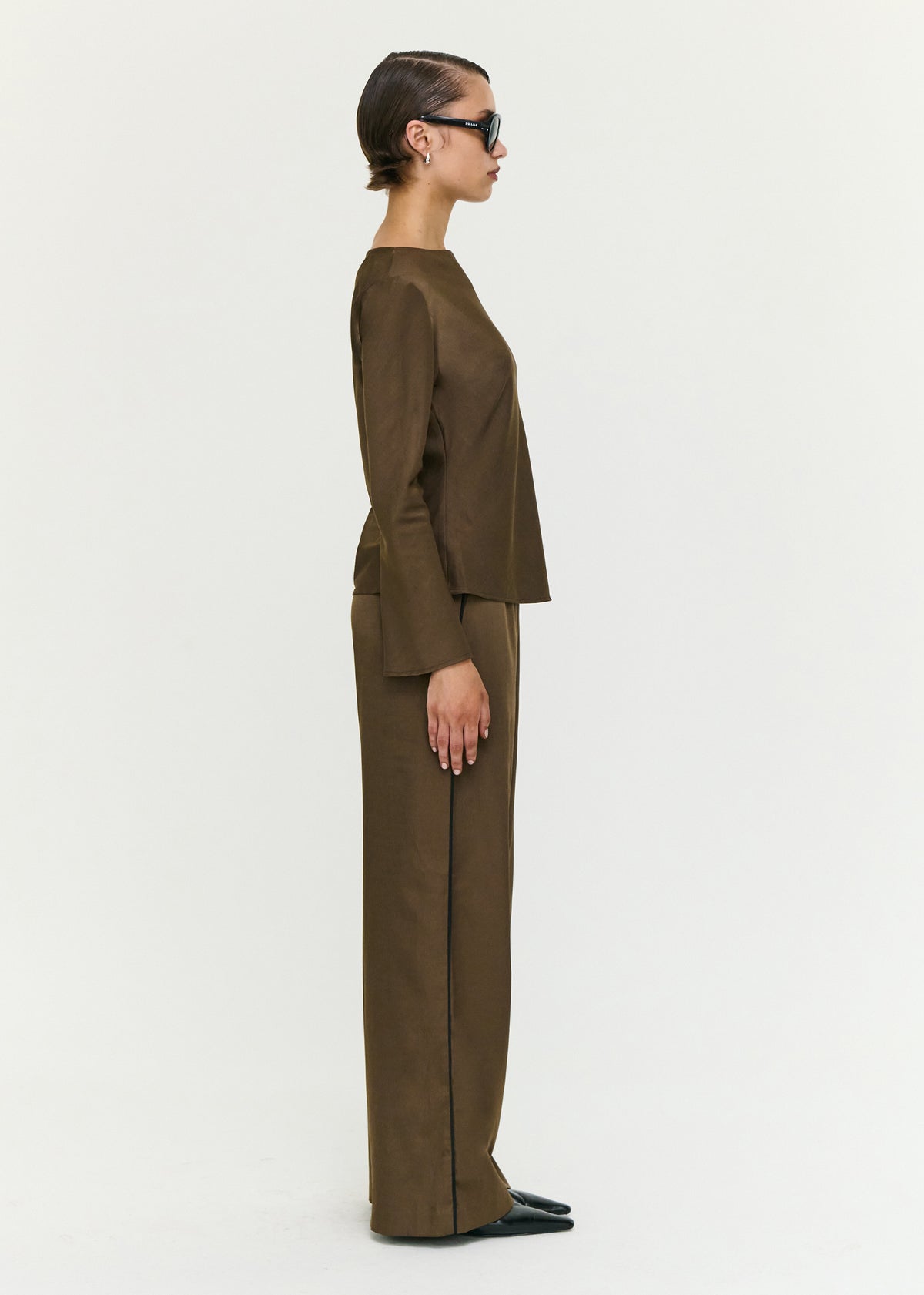 Side view of the Espresso Relaxed Cut Silky Pant, showing a fluid drape finish and a soft woven fabrication.